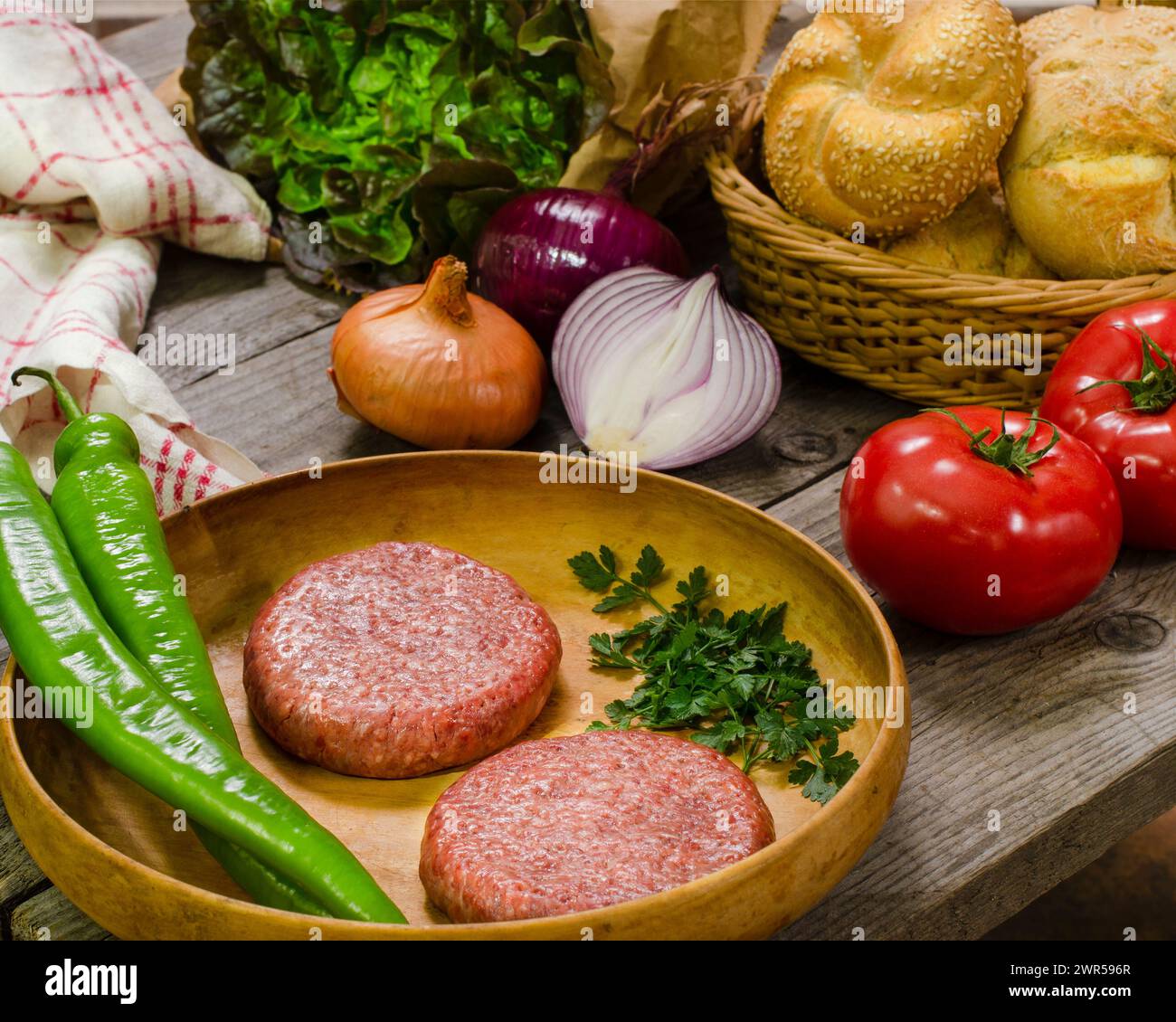 Hamburger in preparazione, scena rustica a casa, natura morta, fotografia gastronomica Foto Stock