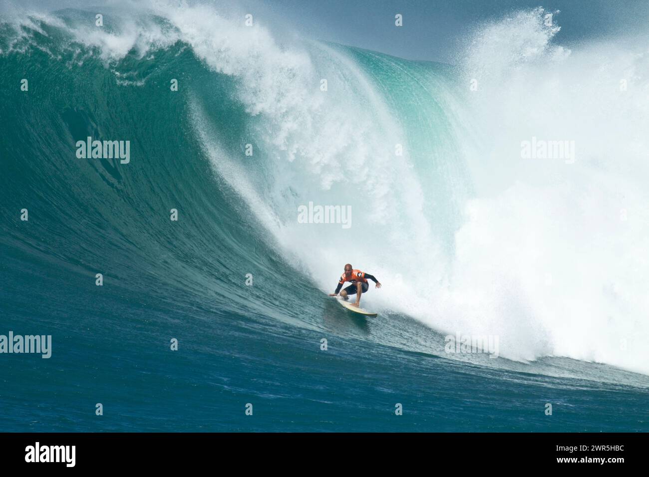 Kelly Slater sta navigando su un'onda enorme al concorso di surf Eddie Aikau Big Wave a Waimea Bay. Foto Stock