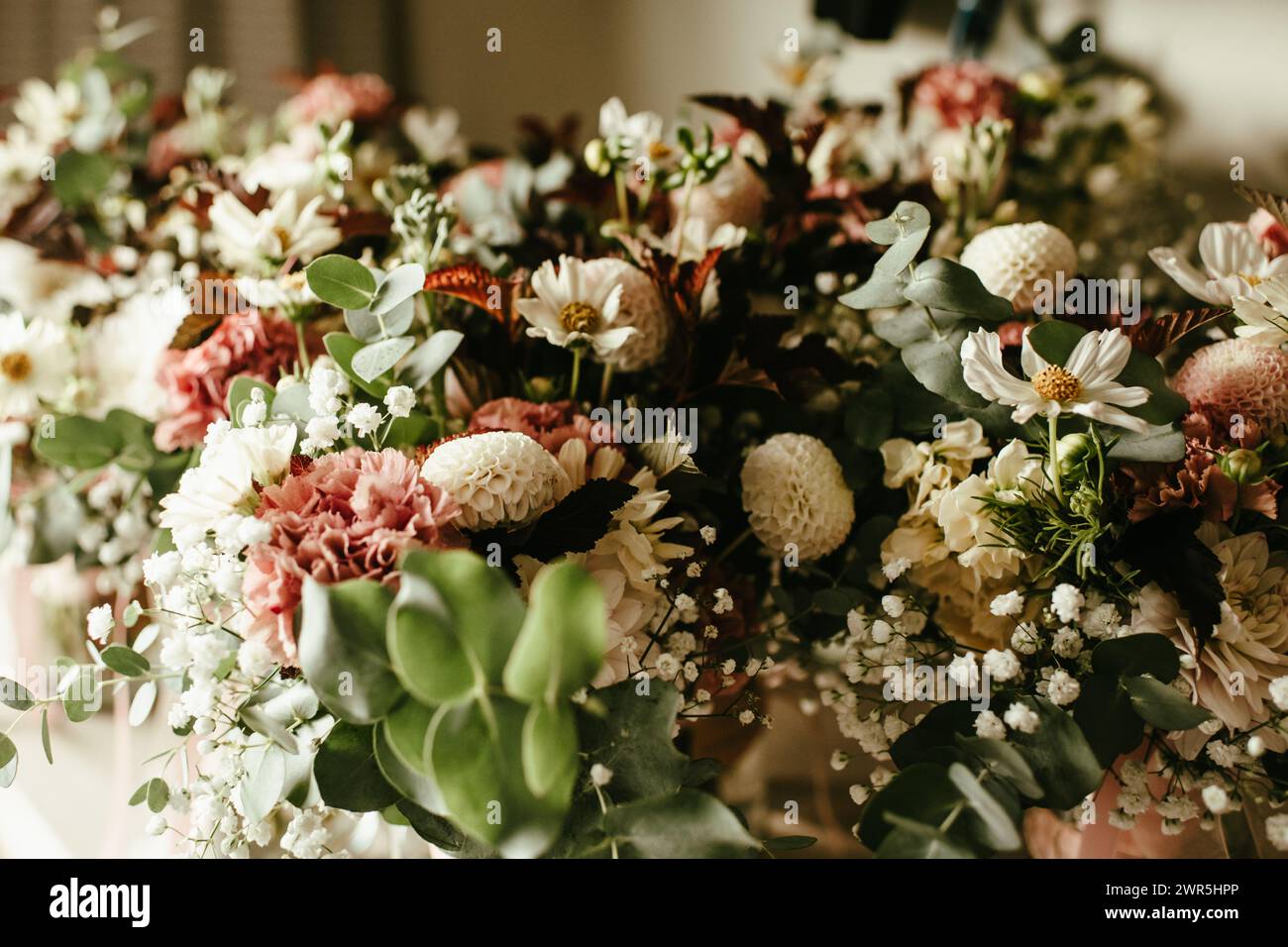 Sfondo floreale di vari fiori bianchi e rosa con vegetazione Foto Stock