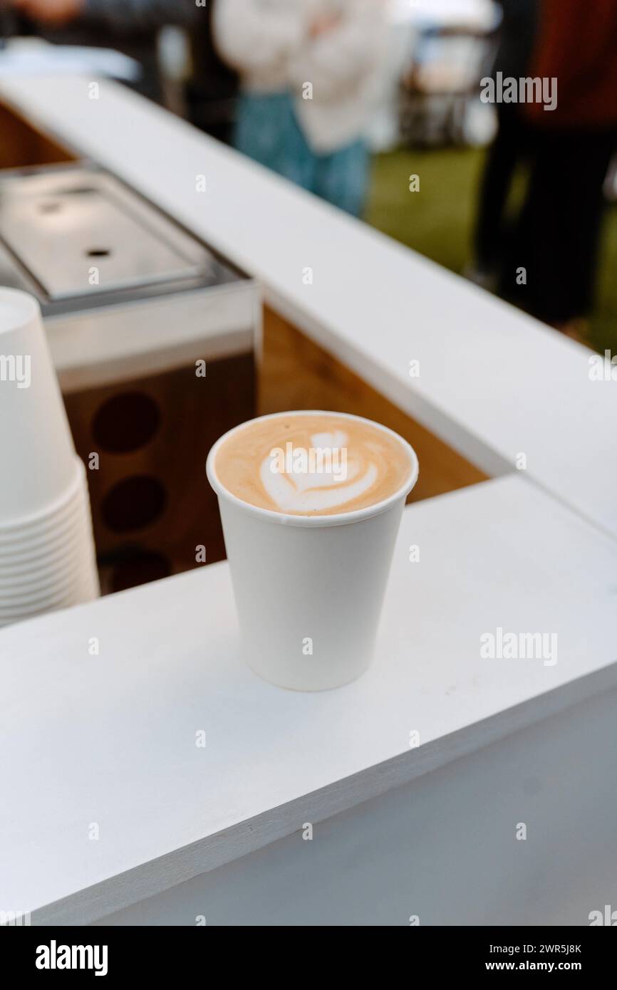 Caffè latte art in tazza di carta bianca Foto Stock