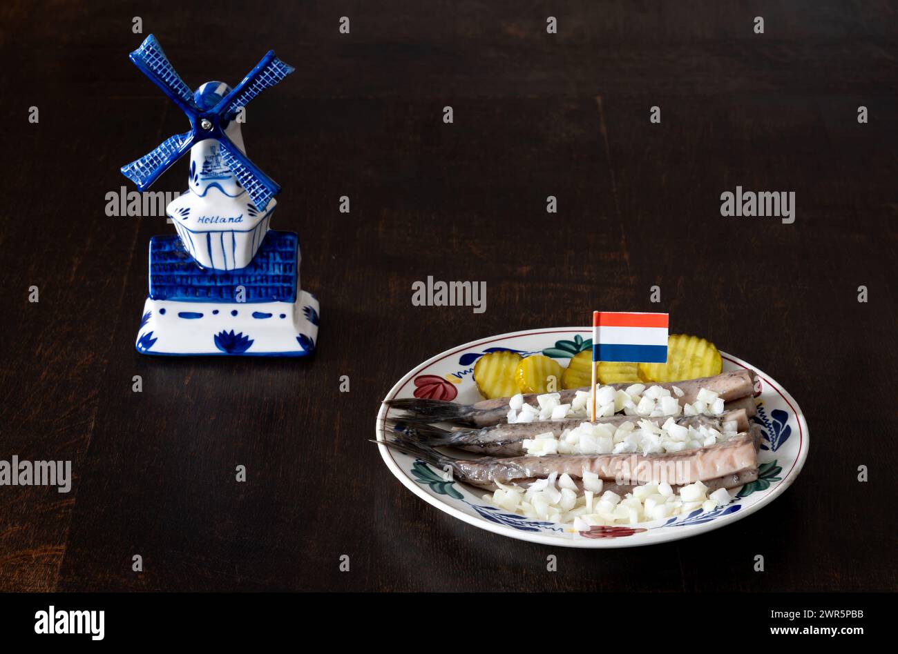 Aringhe crude con sottaceti e cipolla decorate con bandiera a forma di dutth, tipica prelibatezza olandese Foto Stock
