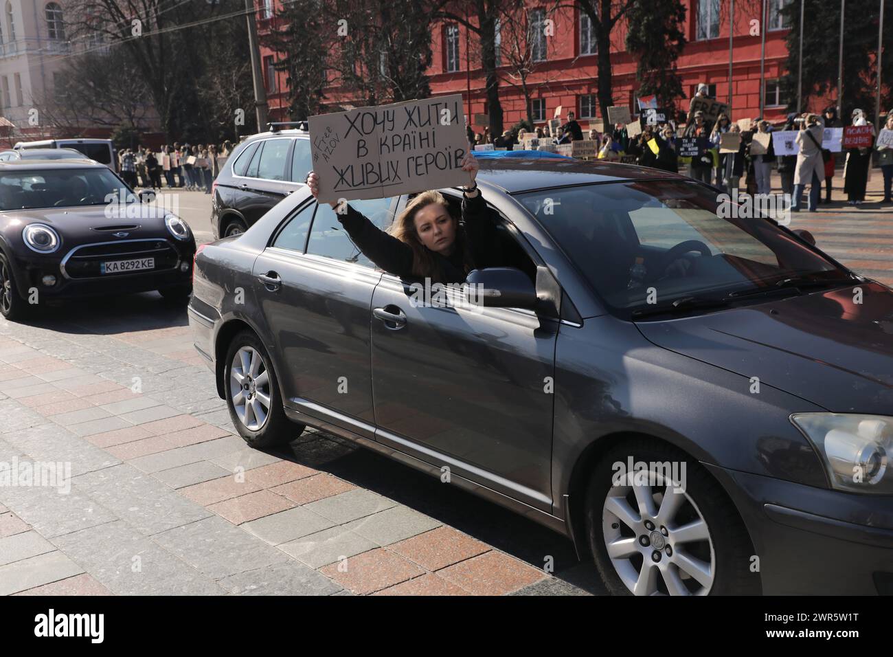 KIEV, UCRAINA - 10 MARZO 2024 - Una donna su un'auto mostra un cartello 'AZOV libero' durante l'azione 'non tacere. "Captivity Kills" che mira a ricordare i difensori catturati dell'Ucraina, in particolare i difensori di Mariupol, fuori dall'Università nazionale Taras Shevchenko di Kiev, Kiev, capitale dell'Ucraina. Foto Stock