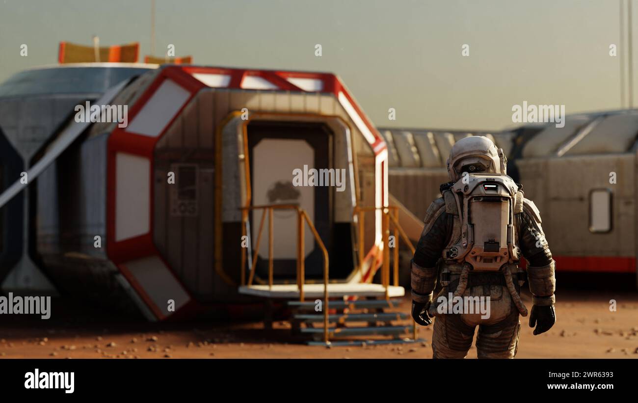 L'astronauta si trova davanti all'ingresso di un habitat modulare su Marte, l'inizio di una nuova era. rendering 3d. Foto Stock