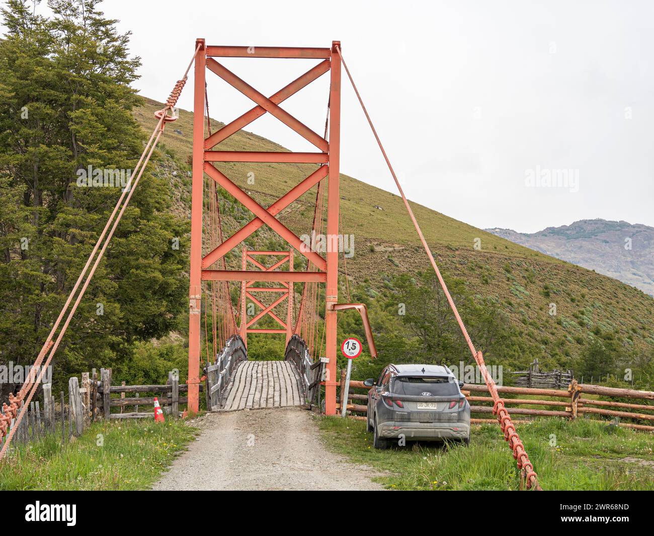 Tradizionale ponte sospeso sotto la cascata Mellizo a sud di Cochrane, limite di peso 1,5 t, SUV parcheggiato, Patagonia, Cile Foto Stock