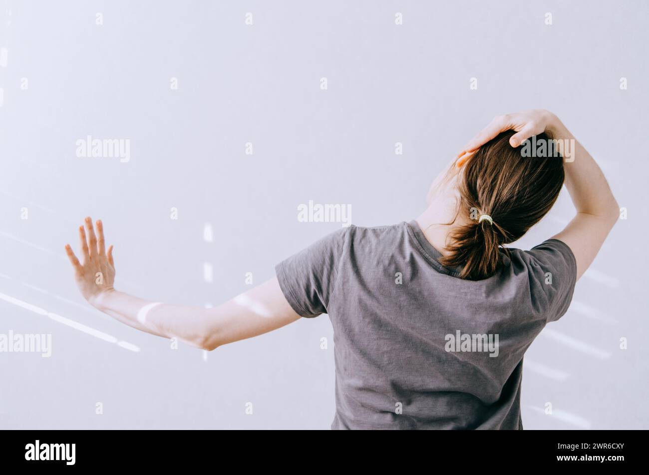 Donna che si allunga il collo e il braccio per rilassarsi Foto Stock