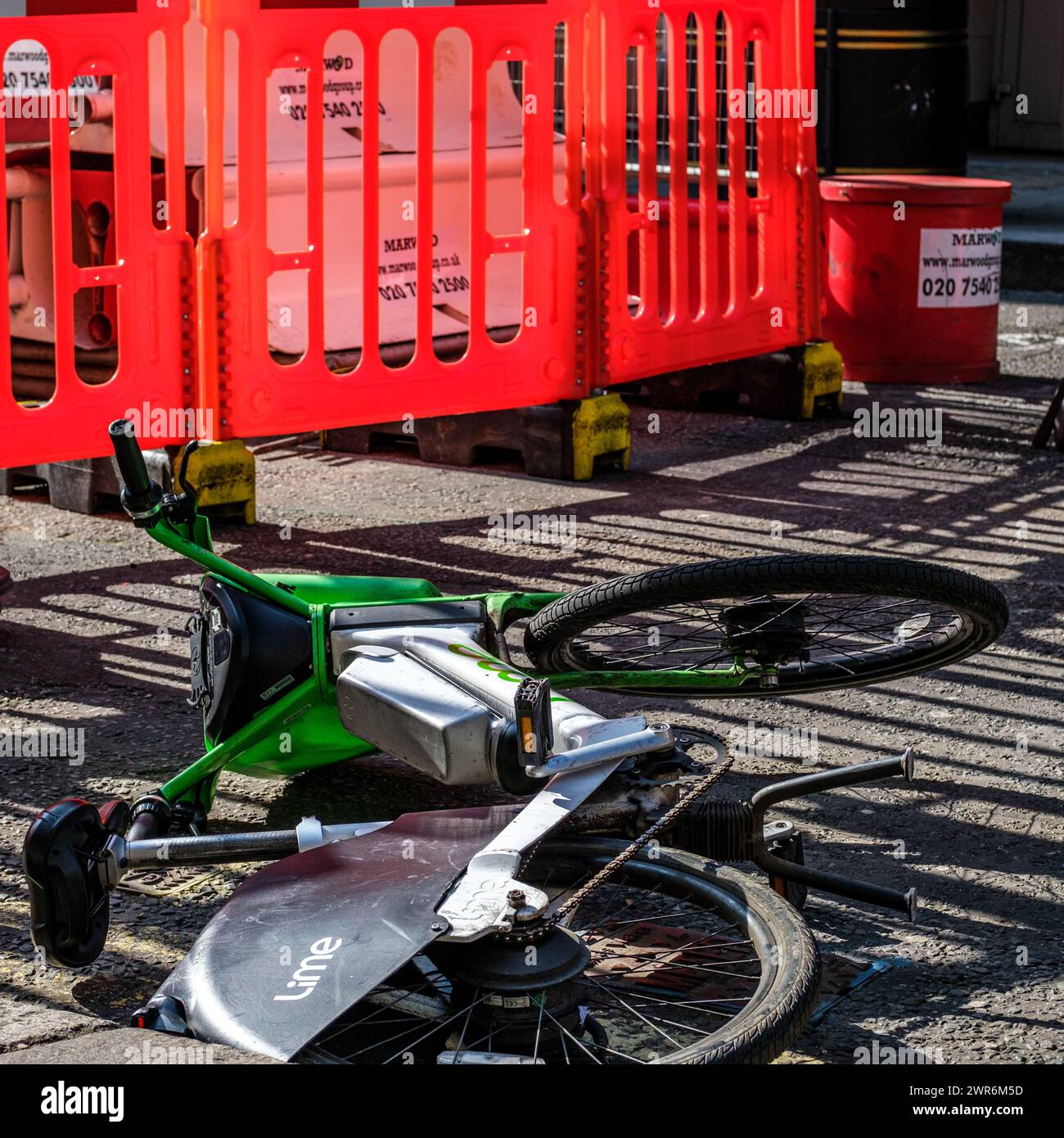 City of Westminster, Londra Regno Unito, 8 marzo 2024, Abandonded Lime Rental Pedel Bike Next to Road Works with No People Foto Stock