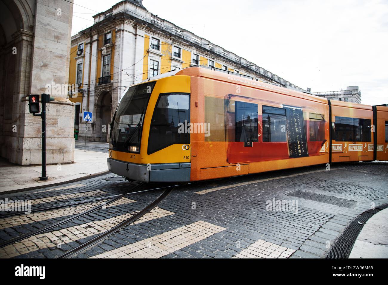 Un tram scivola attraverso le vivaci strade del centro di Lisbona, offrendo un affascinante scorcio nella vibrante atmosfera della città Foto Stock