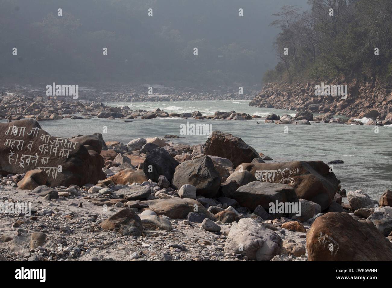 Sulle rive del fiume Ganga a Rishikesh, un messaggio sulla roccia avverte, i livelli dell'acqua stanno salendo, il flusso è rapido. Rischio di affondamento, state attenti Foto Stock