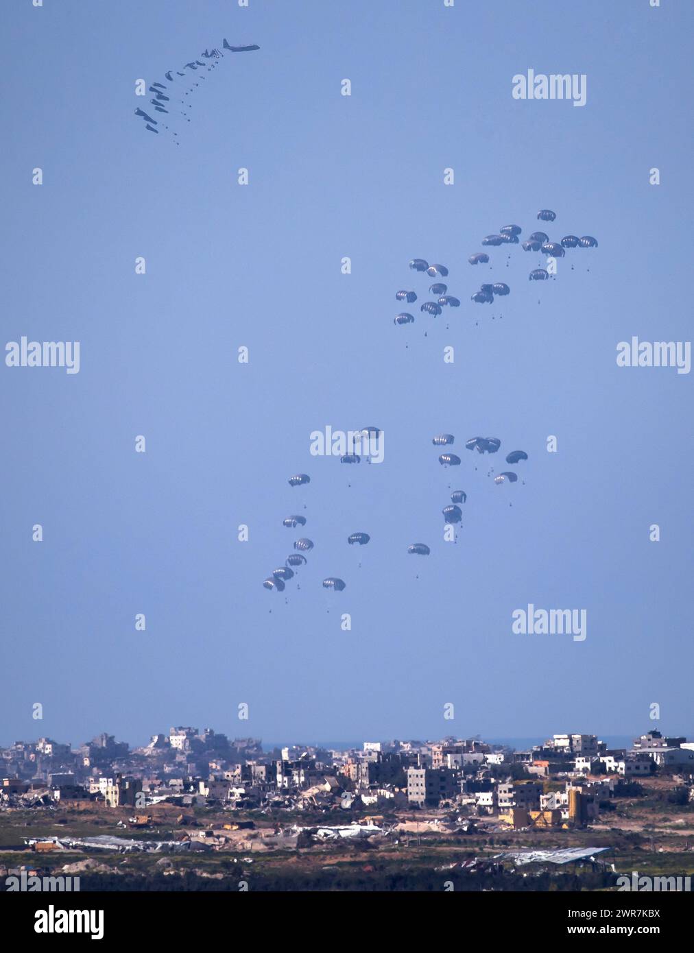 Israele meridionale, Israele. 11 marzo 2024. Il C-130 della United States Air Force rilascia aiuti umanitari con paracadute sulla parte centrale e settentrionale della Striscia di Gaza come visto dall'interno del sud di Israele il 10 marzo 2024. Due aerei precedenti hanno abbandonato gli aiuti immediatamente prima di questo lancio. Ebbene, gli Stati Uniti e altri paesi continuano a far cadere cibo e altri aiuti umanitari ai palestinesi che ne hanno bisogno nella Striscia di Gaza il primo giorno della vacanza musulmana del Ramadan, durata un mese. Mentre continuano i rapporti sui combattimenti tra le forze israeliane e Hamas all’interno di Gaza. Foto di Jim Hollander/UPI credito: UPI/Alamy Live News Foto Stock