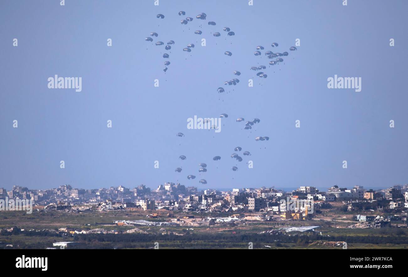Israele meridionale, Israele. 11 marzo 2024. Il C-130 della United States Air Force rilascia aiuti umanitari con paracadute sulla parte centrale e settentrionale della Striscia di Gaza come visto dall'interno del sud di Israele il 10 marzo 2024. Questa foto mostra tre aerei pieni di aiuti mentre scende a Gaza. Gli Stati Uniti e altri paesi continuano a far cadere cibo e altri aiuti umanitari ai palestinesi che ne hanno bisogno nella Striscia di Gaza il primo giorno della vacanza musulmana del Ramadan, durata un mese. Mentre continuano i rapporti sui combattimenti tra le forze israeliane e Hamas all’interno di Gaza. Foto di Jim Hollander/UPI credito: UPI/Alamy Live News Foto Stock