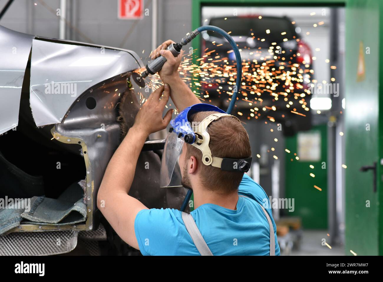 La riparazione carrozzeria di auto da una meccanica in officina Foto Stock