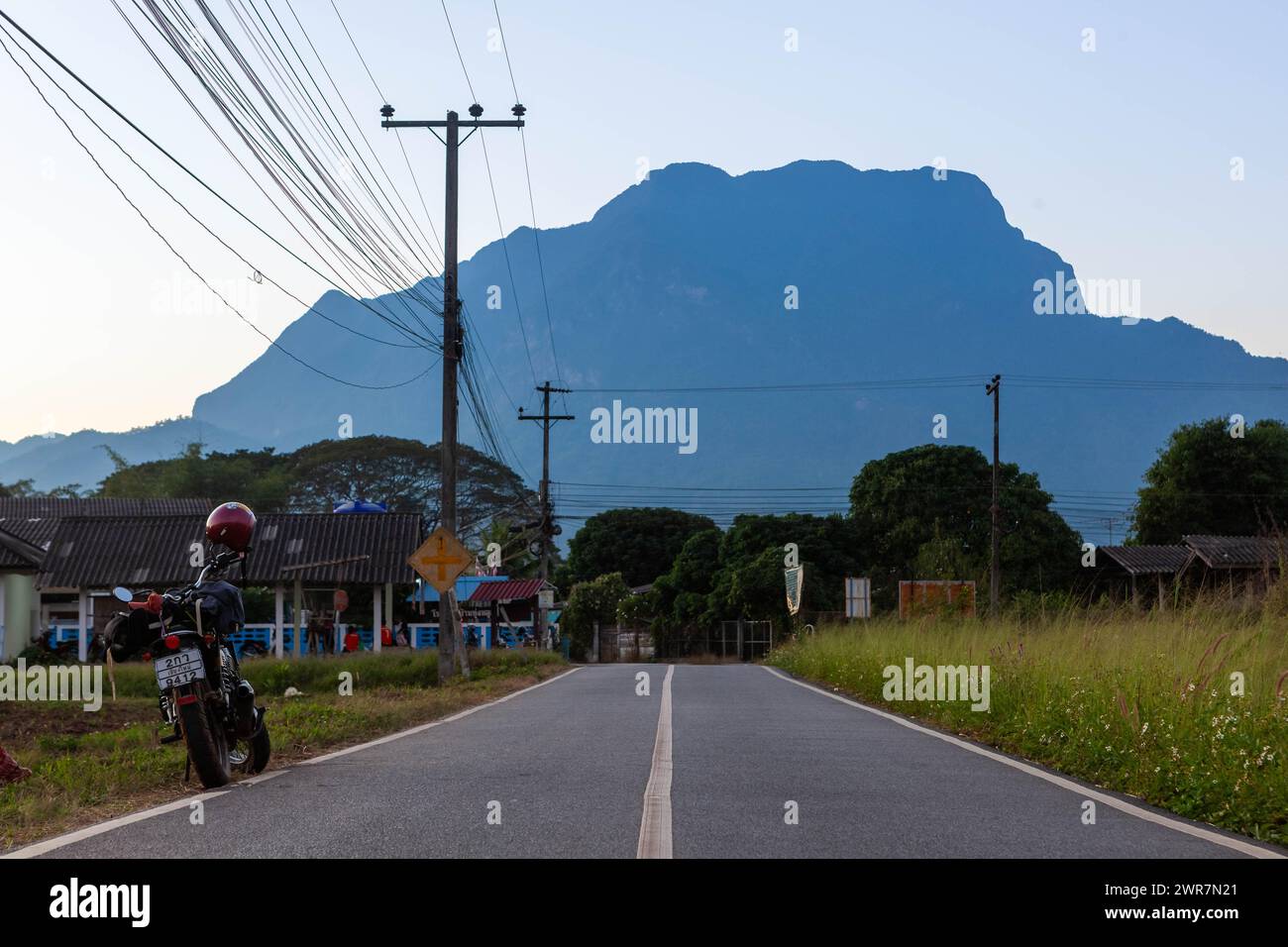 Viaggia in bicicletta attraverso le strade del nord della Thailandia con il monte Chiang Dao sullo sfondo. Foto Stock