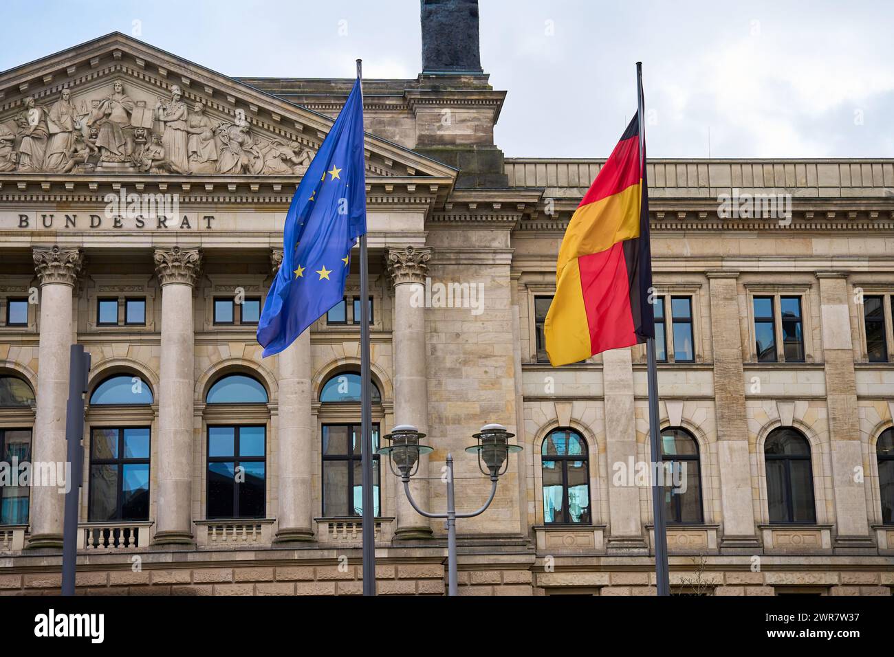 La bandiera nazionale della Germania e la bandiera dell'Unione europea sventolano nel vento sullo sfondo dell'edificio del Bundestag. Edificio governativo in BE Foto Stock