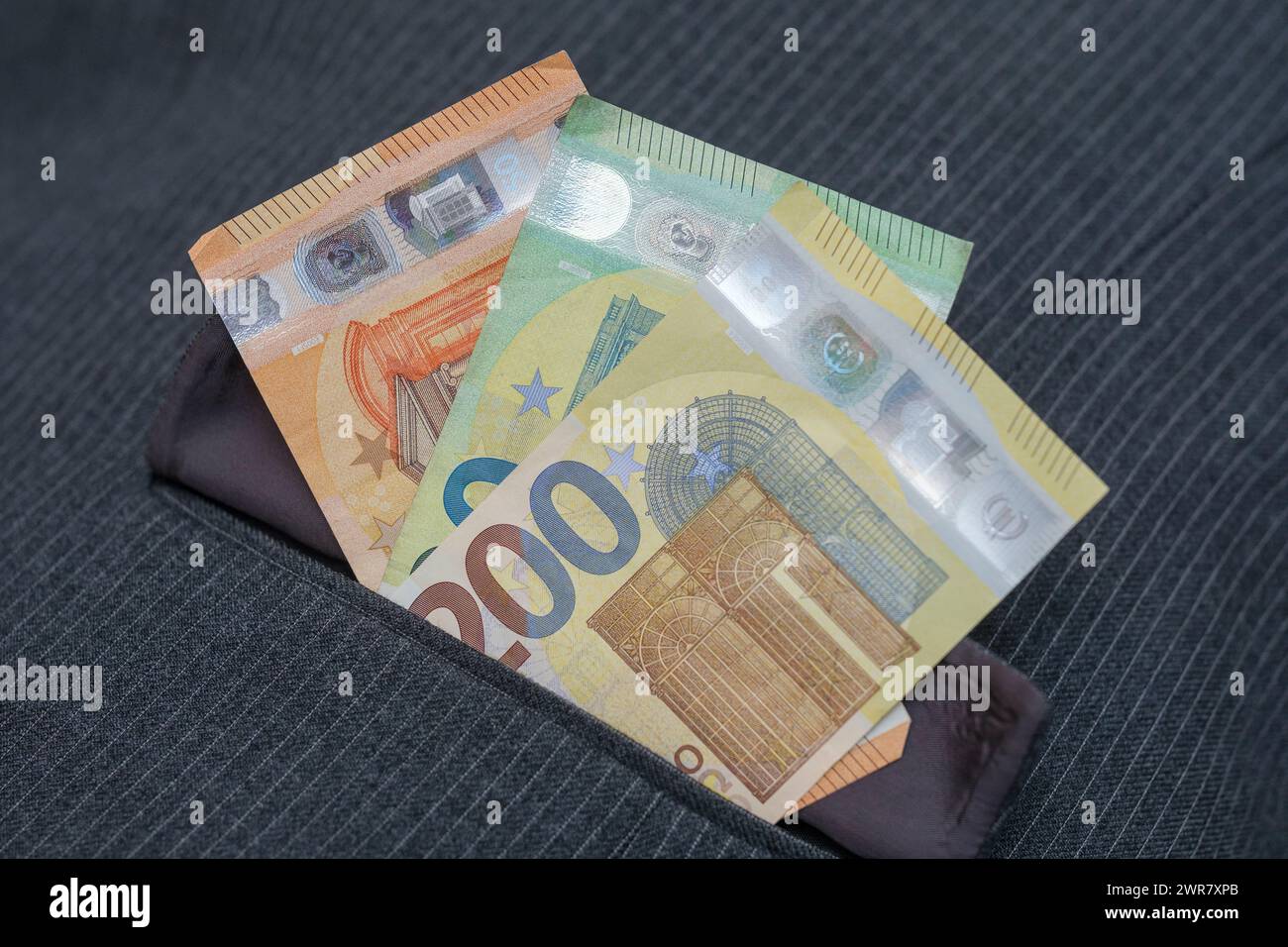 Diverse banconote in euro nella tasca di una tuta di pinstripe Foto Stock