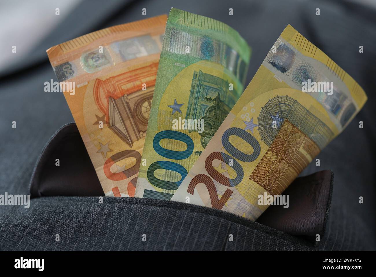 Diverse banconote in euro nella tasca di una tuta di pinstripe Foto Stock