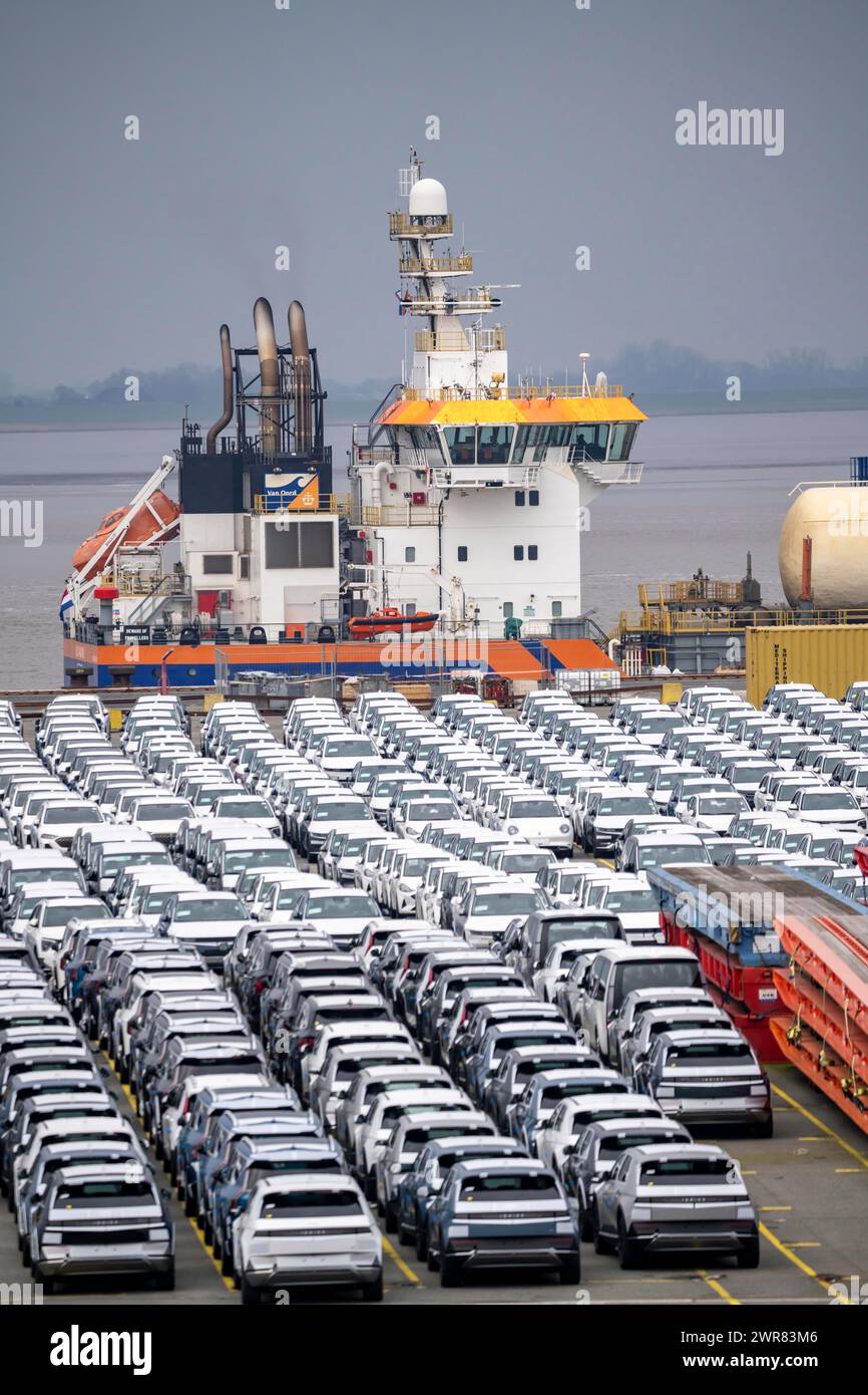 Parcheggio per veicoli d'importazione, centinaia di Hyundai Ioniq, auto elettriche, in attesa di un ulteriore trasporto, dietro di loro, sul Weser, la draga Foto Stock