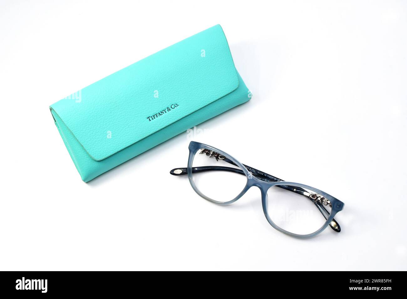 Cardiff, Galles - 9 marzo 2024: Paio di occhiali Tiffany & Co con montature blu e una cassa isolata su fondo bianco Foto Stock