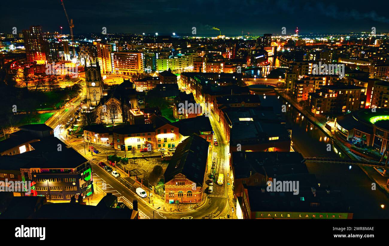 Vista notturna aerea di un vivace paesaggio urbano con strade ed edifici illuminati a Leeds, Regno Unito. Foto Stock