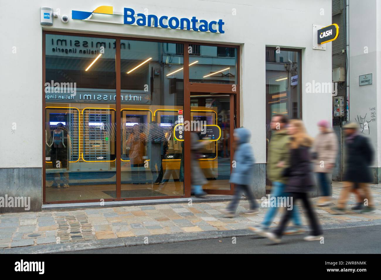 Gli amanti dello shopping passeranno davanti al bancomat interno del bancomat Bancontact, un punto di CASSA neutrale della banca, nella strada dello shopping a Gand / Gent, nelle Fiandre orientali, Belgio Foto Stock