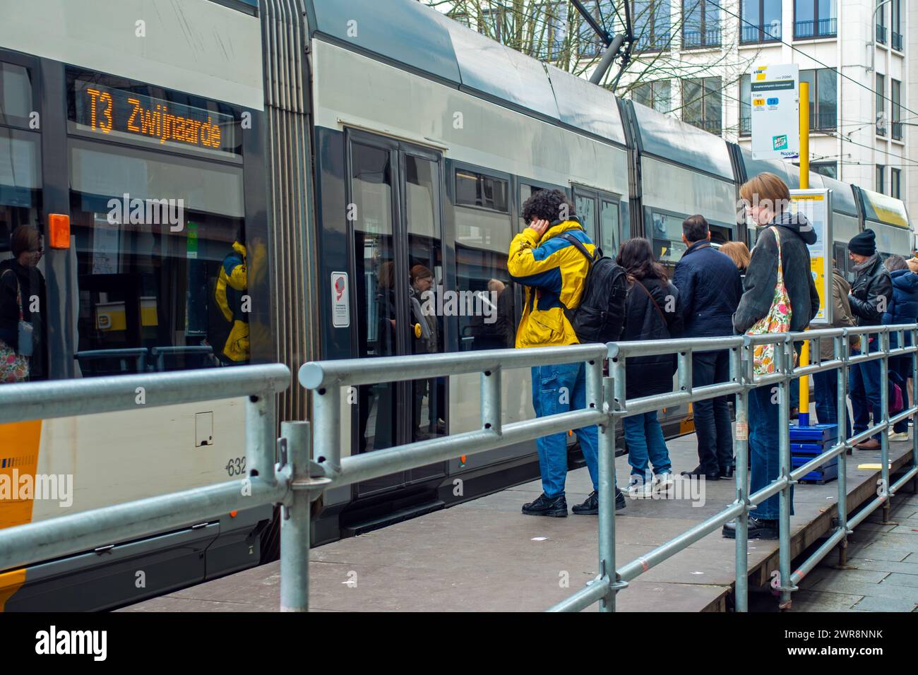 Pendolari e acquirenti salgono sul tram alla fermata del tram della compagnia di trasporti fiamminga De Lijn nel centro di Gand, nelle Fiandre Orientali, in Belgio Foto Stock