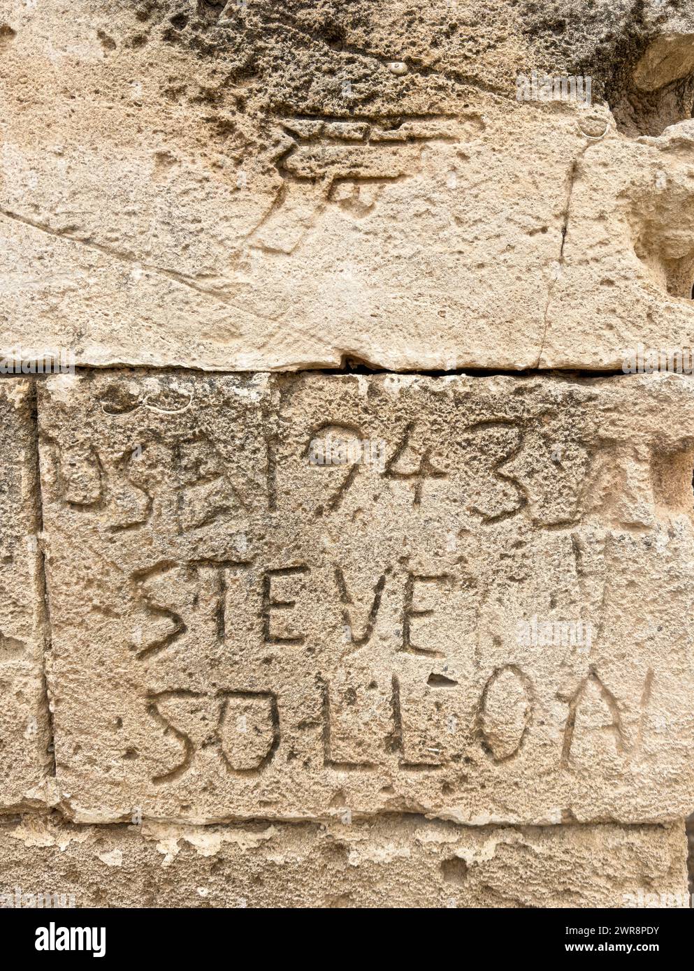 Graffiti scolpiti in un muro dell'Anfiteatro Romano a El Jem (Thysdrus) che mostra il nome Steve Sollon, USA, 1943 e un'immagine di una pistola a mano, Tunisi Foto Stock
