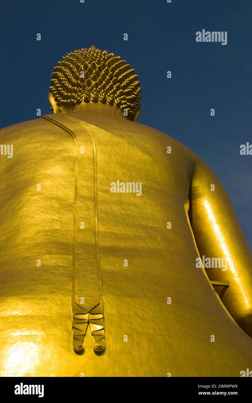 Foto ravvicinata di una statua dorata adornata con numerosi oggetti più piccoli sulla schiena Foto Stock