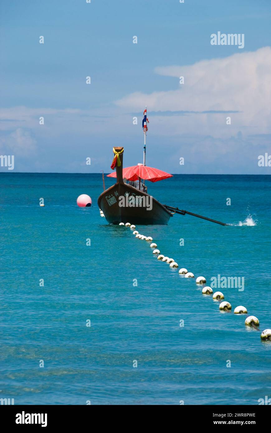 Barca ancorata nel mare tra molte boe colorate Foto Stock