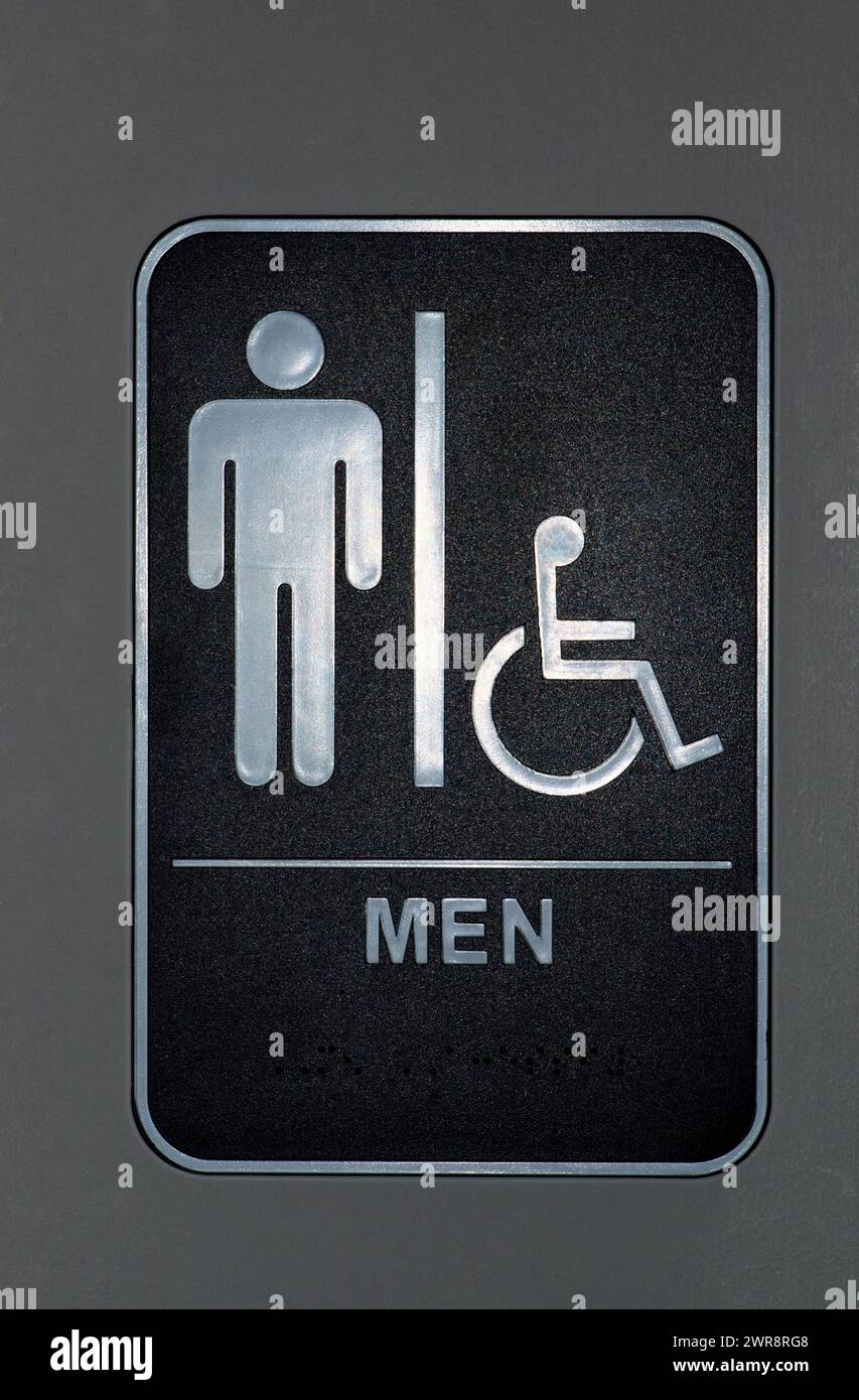 Il bagno degli uomini e il cartello per disabili su una porta. Il Braille può anche essere visto in fondo al cartello. Formato verticale. Foto Stock