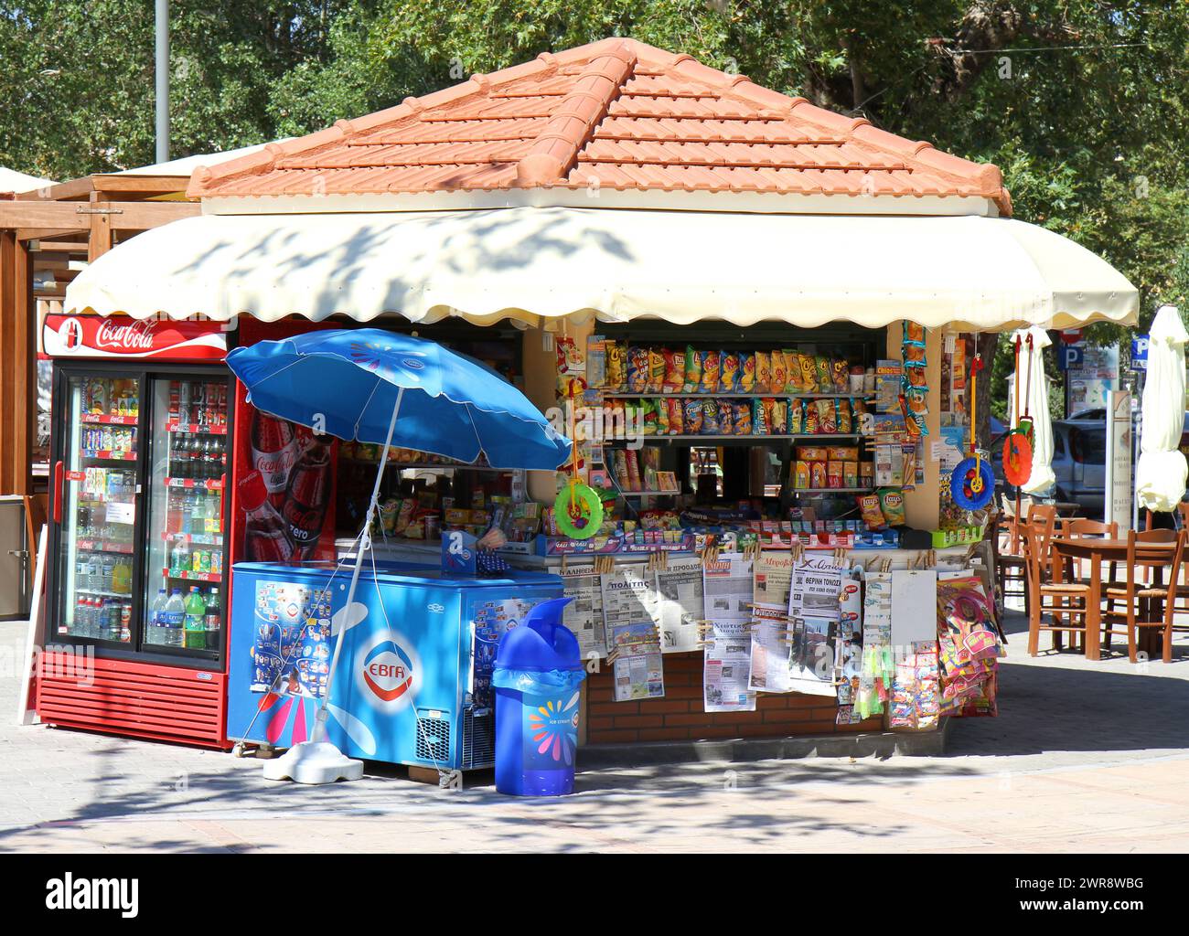 CHIOS, GRECIA - 11 LUGLIO 2010: Uno stand di notizie greco colorato con cibo e bevande in una calda giornata estiva Foto Stock