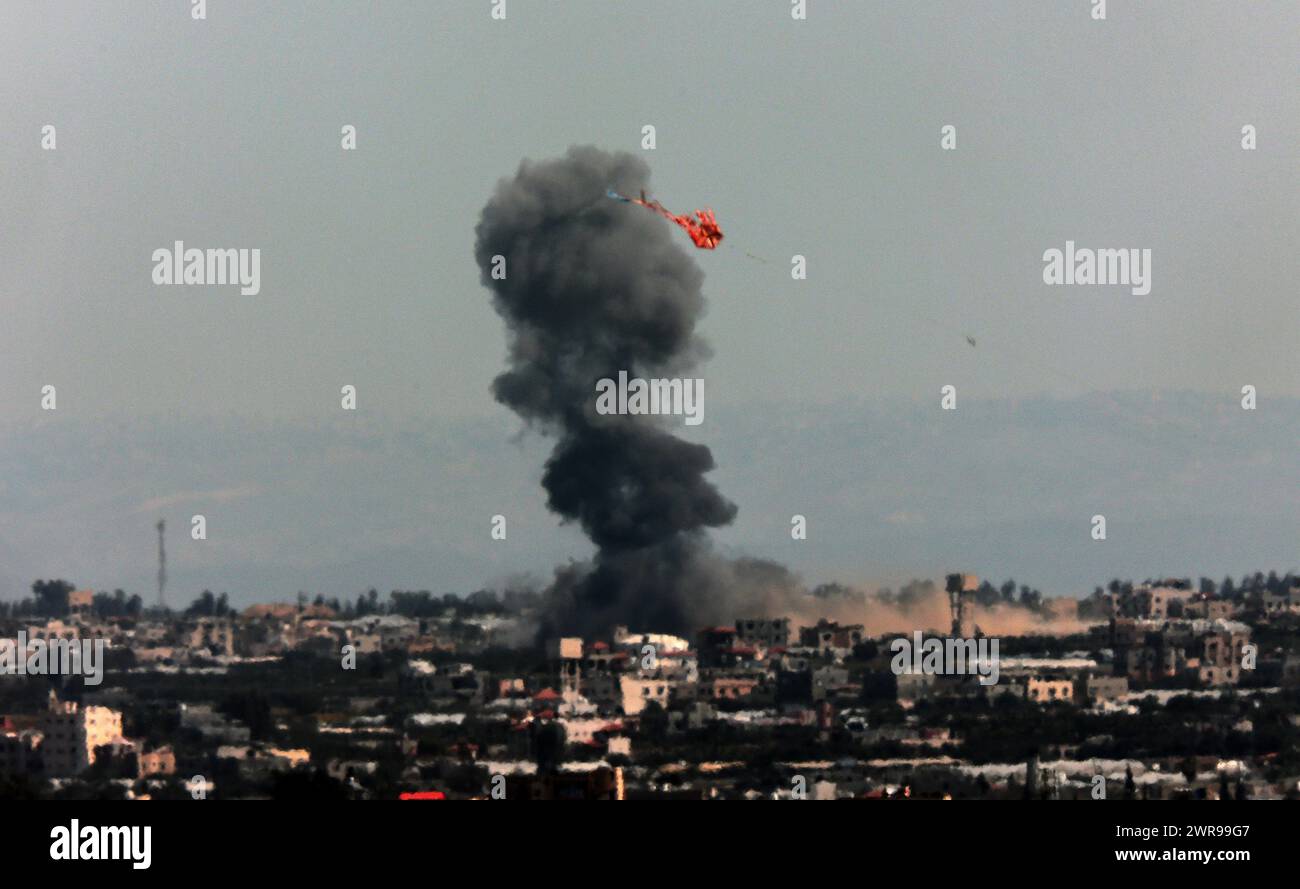 Rafah, Gaza. 11 marzo 2024. Una foto scattata da Rafah mostra fumo che si diffonde su Khan Yunis nella striscia di Gaza meridionale durante il bombardamento israeliano, lunedì 11 marzo 2024. Fonti locali dicono che altri due bambini sono morti a causa di grave malnutrizione e disidratazione all'ospedale Kamal Adwan di Beit Lahia, nel nord di Gaza.questo porta il numero totale di bambini che hanno perso la fame a 27. Foto di Ismael Mohamad/UPI. Crediti: UPI/Alamy Live News Foto Stock