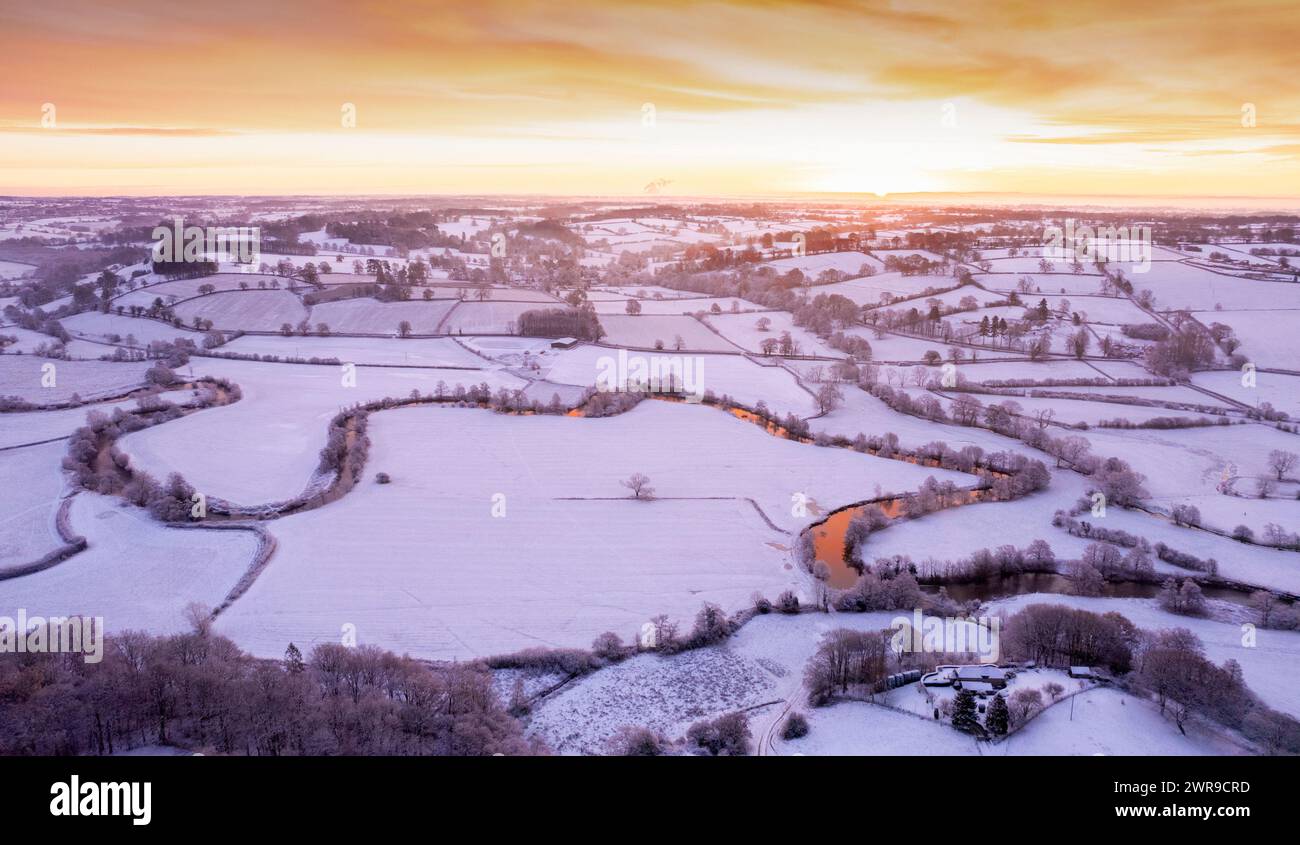 29/11/21 dopo che la temperatura notturna è scesa ben al di sotto del gelo, l'alba si rompe su un paesaggio innevato mentre la prima luce del sole del giorno si riversa Foto Stock