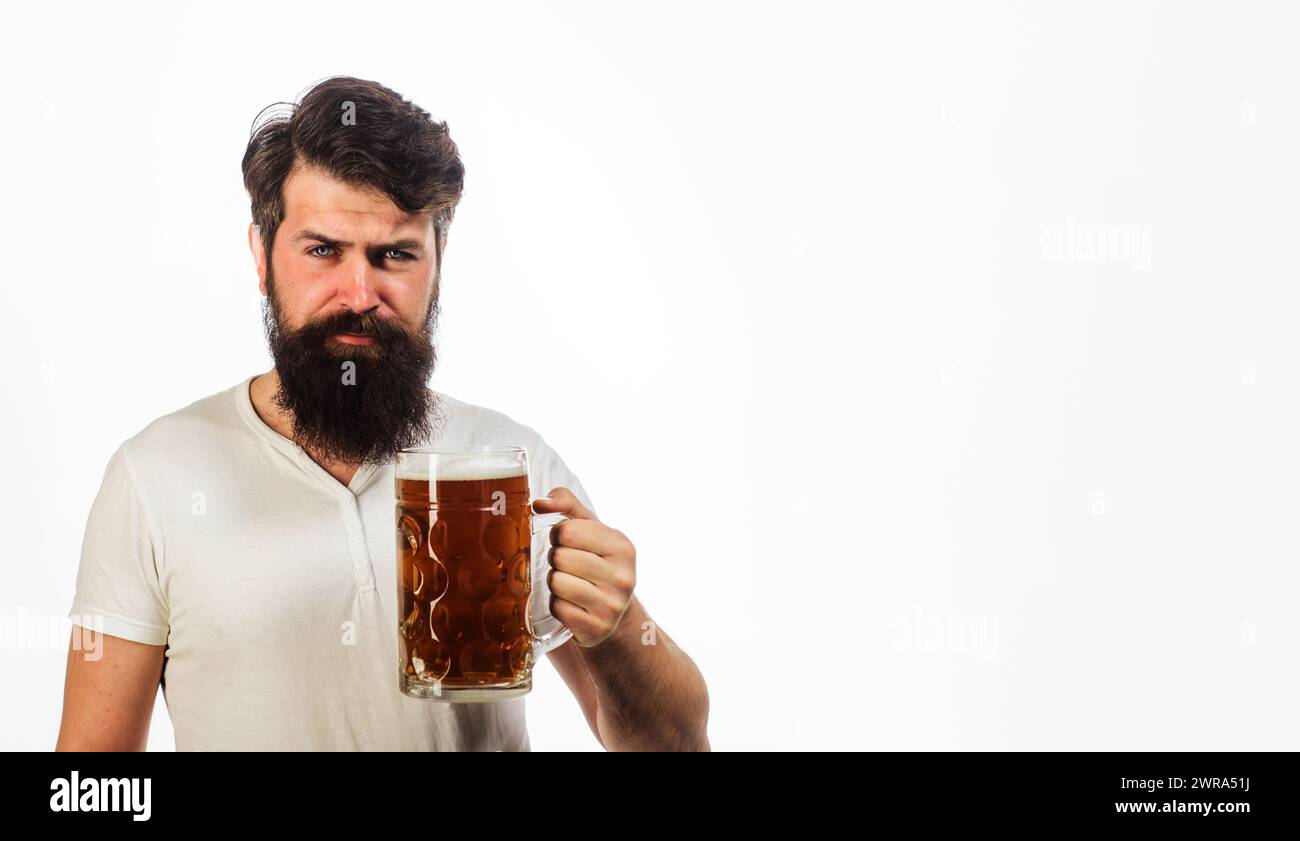 Un uomo barbuto serio con birra da tazza. Festival dell'Oktoberfest. Barbuti hipster che assaggia birra fresca prodotta. Degustazione di birra. Bevande, alcolici e tempo libero Foto Stock