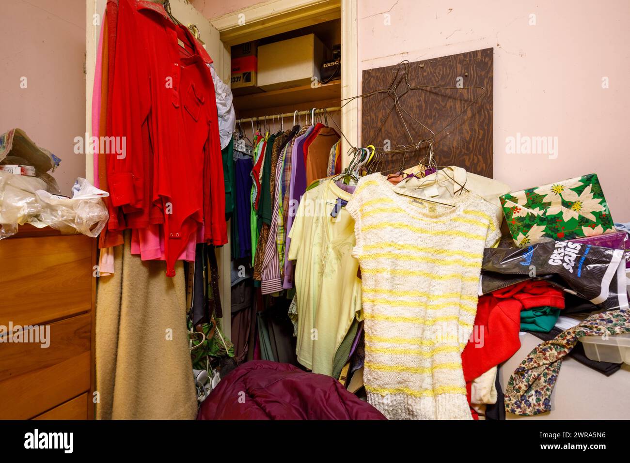 Un armadio pieno di vestiti in una casa abbandonata. Foto Stock
