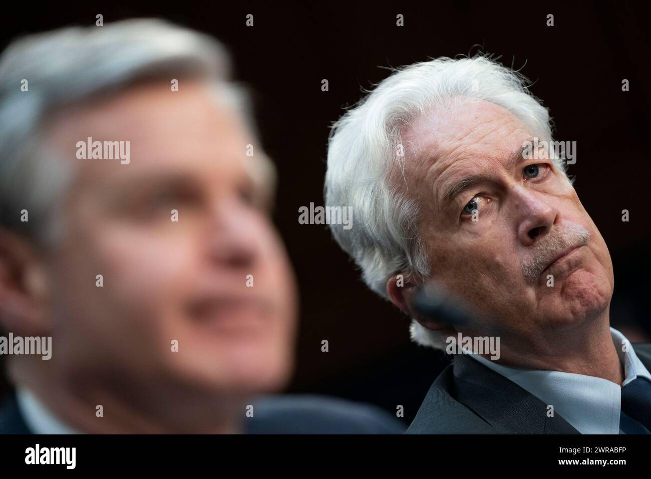 Washington, Stati Uniti. 11 marzo 2024. Il direttore della Central Intelligence Agency, William Burns, guarda come il direttore del Federal Bureau of Investigation Christopher Wray, durante un'audizione del Senate Intelligence Committee, parla di "esaminare le minacce mondiali" al Campidoglio degli Stati Uniti a Washington, DC, lunedì 11 marzo 2024. Foto di Bonnie Cash/UPI credito: UPI/Alamy Live News Foto Stock