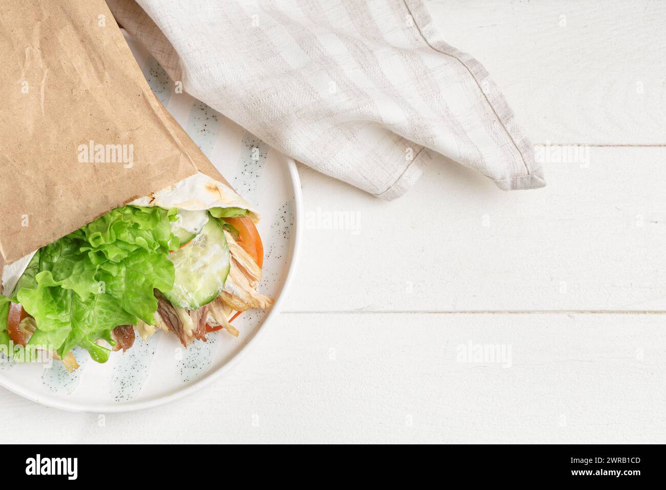 Piatto con gustoso kebab doner su un tavolo di legno chiaro Foto Stock