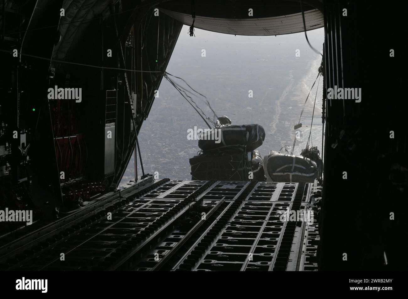 Un C-130J Super Hercules della U.S. Air Force conduce un airdrop di assistenza umanitaria su Gaza, 11 marzo 2024. Gli aiuti umanitari comprendono pacchetti di cibo e acqua, che forniscono pasti ai civili più bisognosi di assistenza a causa del conflitto in corso nella regione. Il comando centrale degli Stati Uniti e gli Stati Uniti sono impegnati a sostenere la missione umanitaria per gli aiuti alla popolazione di Gaza. (Foto di cortesia dell'aeronautica militare statunitense) Foto Stock