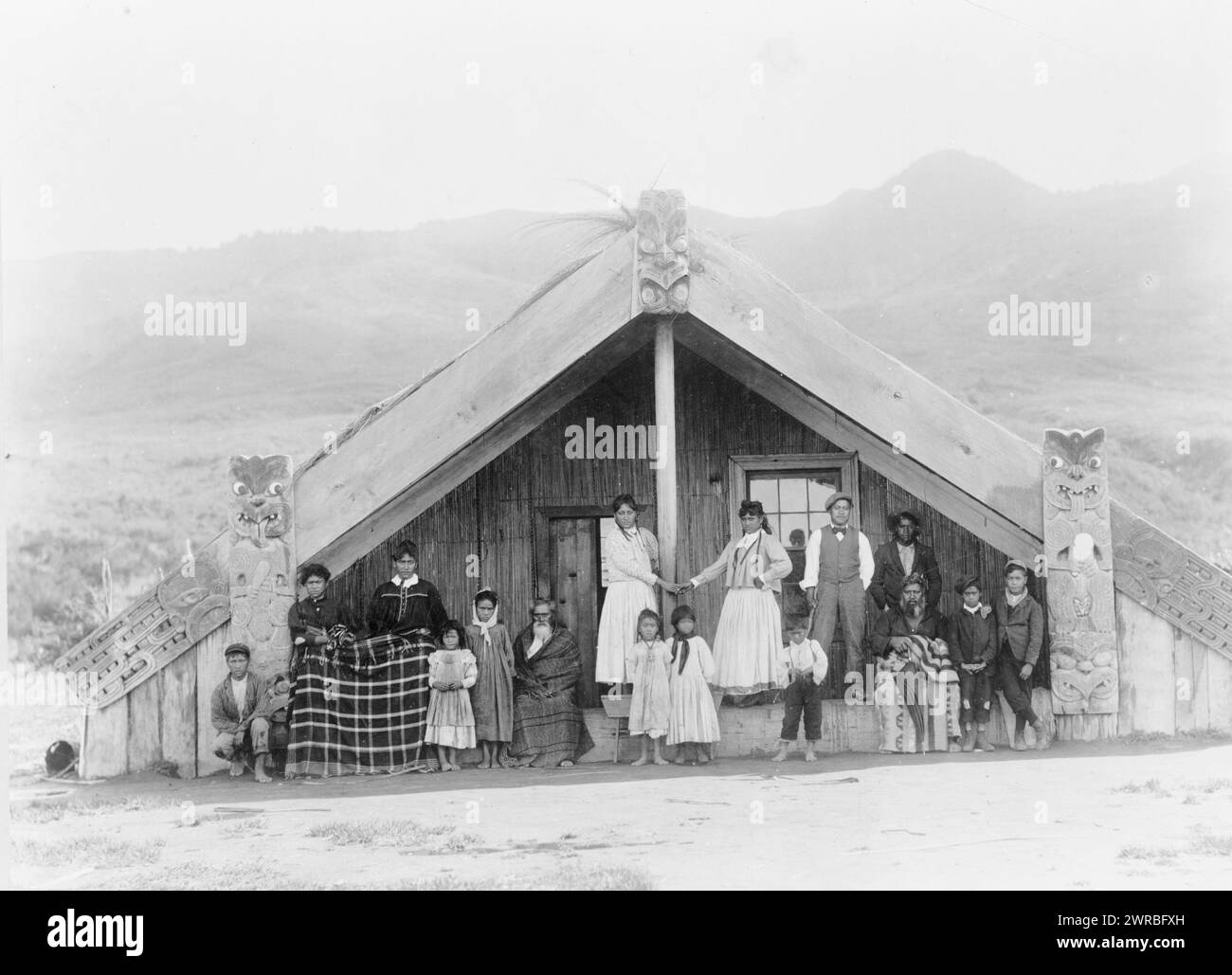 Nuova Zelanda, Maori nella loro casa parlante, uomini, donne e bambini sul portico di struttura cerimoniale con sezioni in legno intagliato., tra il 1880 e il 1920, Maori (popolo neozelandese), Structures, 1890-1920, Group Portraits, 1890-1920. ritratti di gruppo, 1890-1920, ritratti, 1890-1920, 1 stampa fotografica Foto Stock