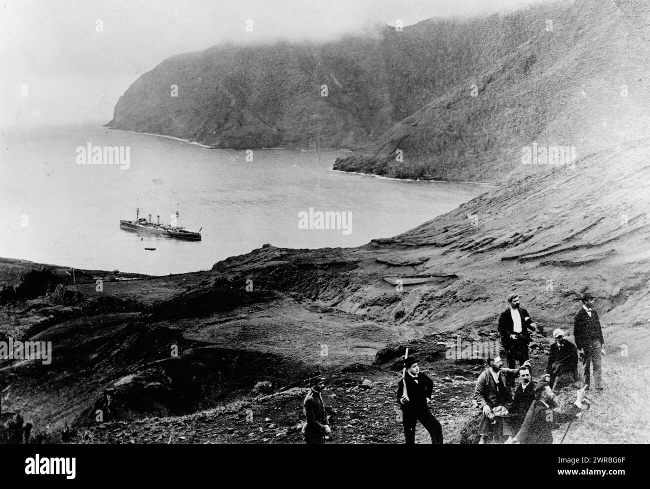 Cile - l'isola di Robinson Crusoe, un tempo occupata dal castello, Alexander Selkirk, e ora sede di una colonia penale e del terreno di pesca di lobstermen, gruppo di uomini sulla collina dell'isola, e nave sull'acqua sullo sfondo., tra ca. 1890 e 1922, Isole, Cile, Isole Juan Fernández, 1880-1930, stampe fotografiche, 1880-1930., stampe fotografiche, 1880-1930, 1 stampa fotografica Foto Stock