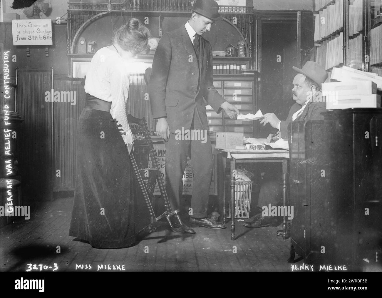 Miss Mielke, la fotografia mostra Henry Mielke (nato nel 1871) sua figlia Henrietta (nato nel 1897) e un altro uomo. Henry Mielke era proprietario di un negozio e membro dell'organizzazione "Gold for Iron" (Gold fur Eisen) che dava anelli di ferro alle persone in cambio di oro e gioielli che venivano utilizzati per sostenere lo sforzo bellico tedesco durante la prima guerra mondiale Fotografia probabilmente scattata nel negozio di Mielke situato in Second Avenue all'angolo di 87th Street a New York City., 1914 ottobre 22, Guerra Mondiale, 1914-1918, Glass negatives, 1 negativo: vetro Foto Stock