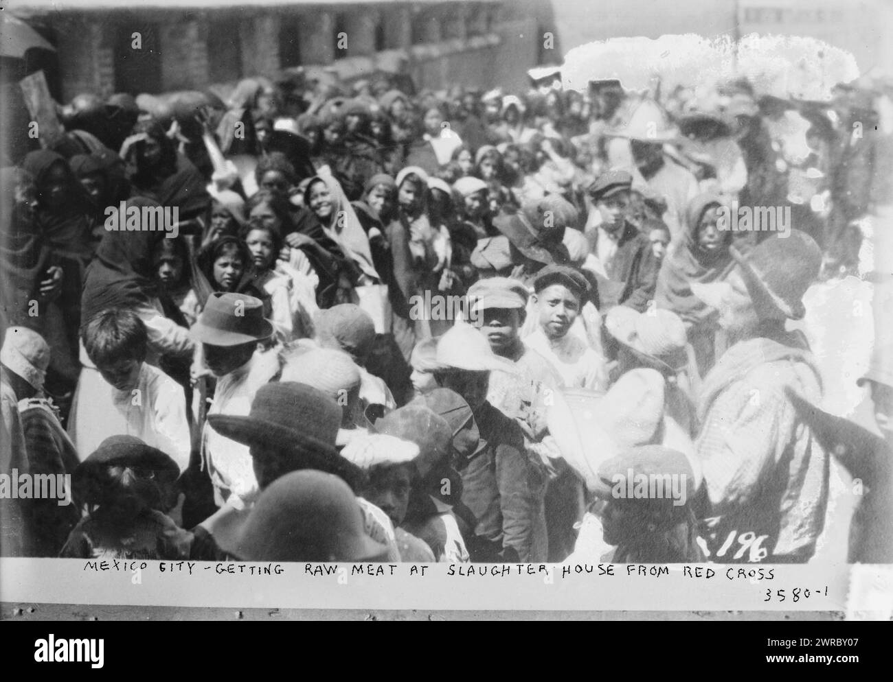 Città del Messico, prendendo carne cruda al macello dalla Croce Rossa, la fotografia mostra messicani affamati in fila per ricevere cibo durante le condizioni di carestia nel 1915 durante la rivoluzione messicana., 1915, città del Messico, Glass negative, 1 negativo: Vetro Foto Stock