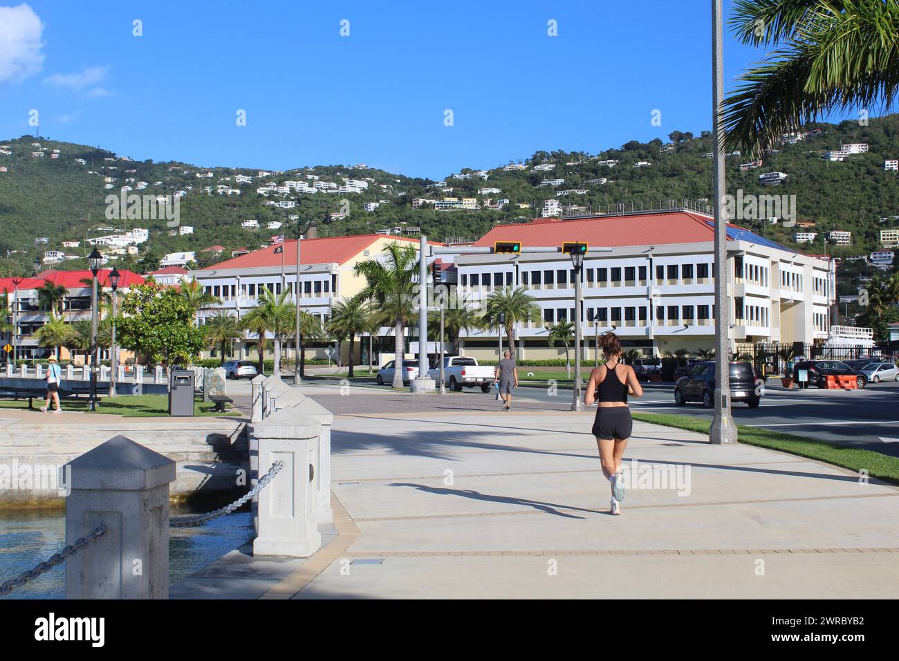 Donna che cammina su un marciapiede acciottolato vicino al porto di Charlotte Amalie, Isole Vergini americane Foto Stock