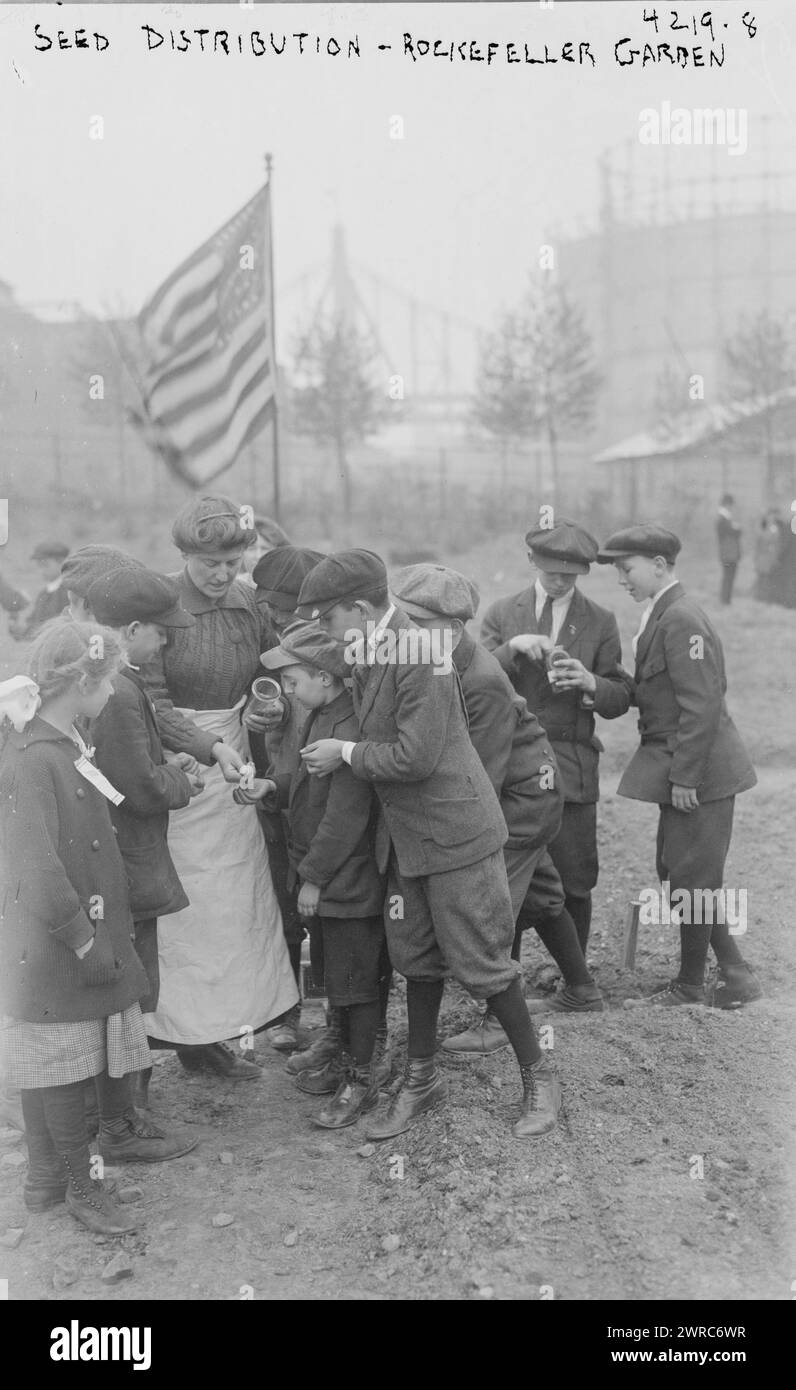 Distribuzione di semi, Rockefeller Garden, donna che distribuisce semi ai bambini in un Rockefeller Garden nella sua nuova posizione in 65th Street e Avenue A nel maggio 1917. La National Plant, Flower and Fruit Guild curava il giardino donato dalla Rockefeller Foundation., 1917 maggio, Glass negatives, 1 negative: Glass Foto Stock