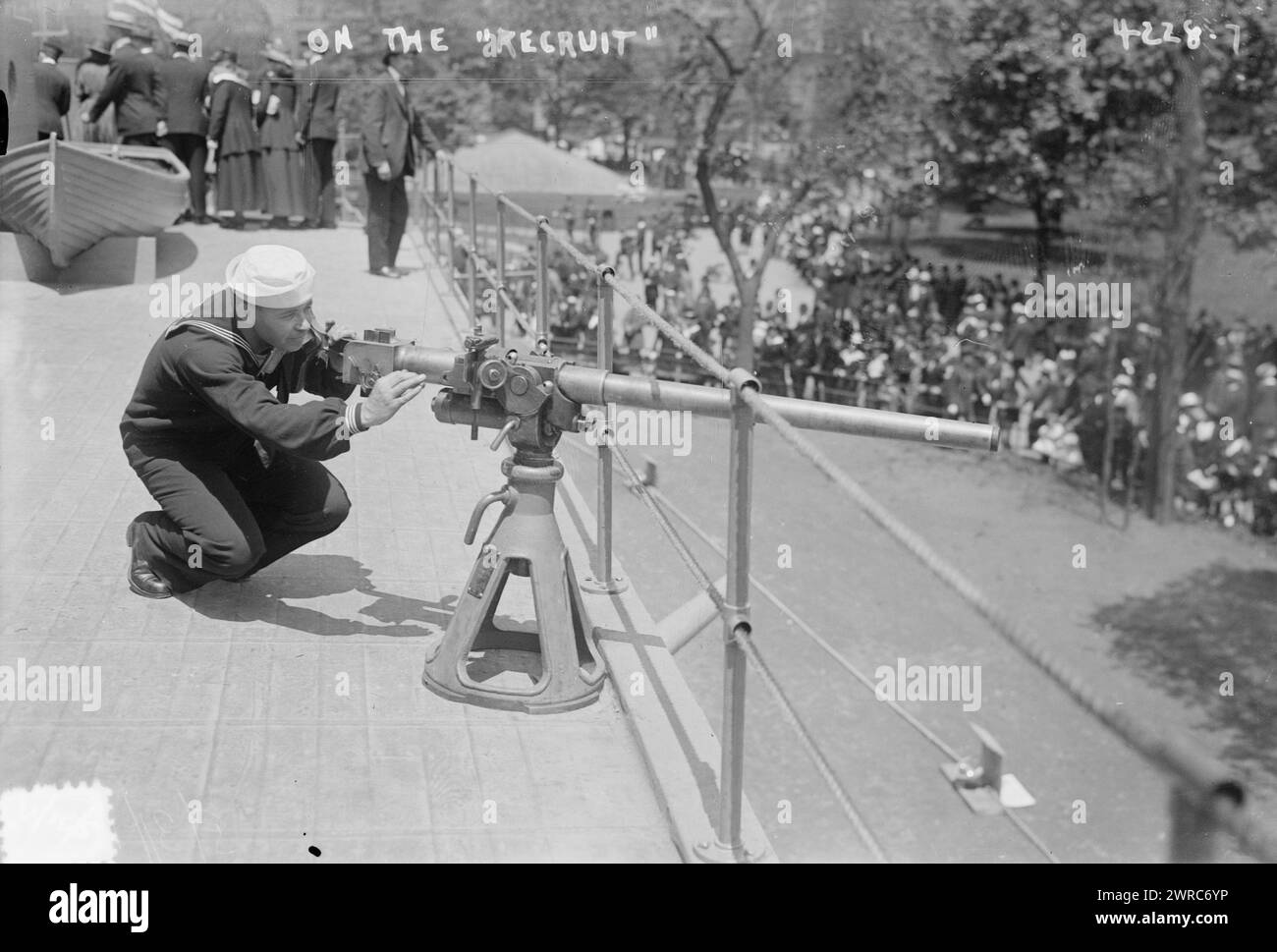 Sulla RECLUTA, la fotografia mostra un marinaio che mostra un "cannone da ponte", forse un Hotchkiss 1 pounder, a bordo della U.S. Recruit, una falsa nave da battaglia costruita a Union Square, New York City dalla Marina per reclutare marinai e vendere obbligazioni Liberty durante la prima guerra mondiale La fotografia è stata scattata il giorno del Memorial Day, 30 maggio 1917, giorno del "lancio" della nave., 1917 maggio 30, Guerra Mondiale, 1914-1918, Glass negatives, 1 negativo: vetro Foto Stock