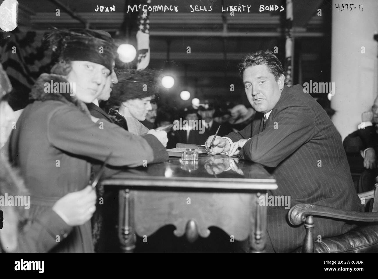 John McCormack vende obbligazioni Liberty, la fotografia mostra il tenore irlandese americano John McCormack (1884-1945) seduto a un tavolo, vendendo obbligazioni Liberty a persone durante la prima guerra mondiale, 1917 o 1918, guerra mondiale, 1914-1918, Glass negatives, 1 negativo: vetro Foto Stock