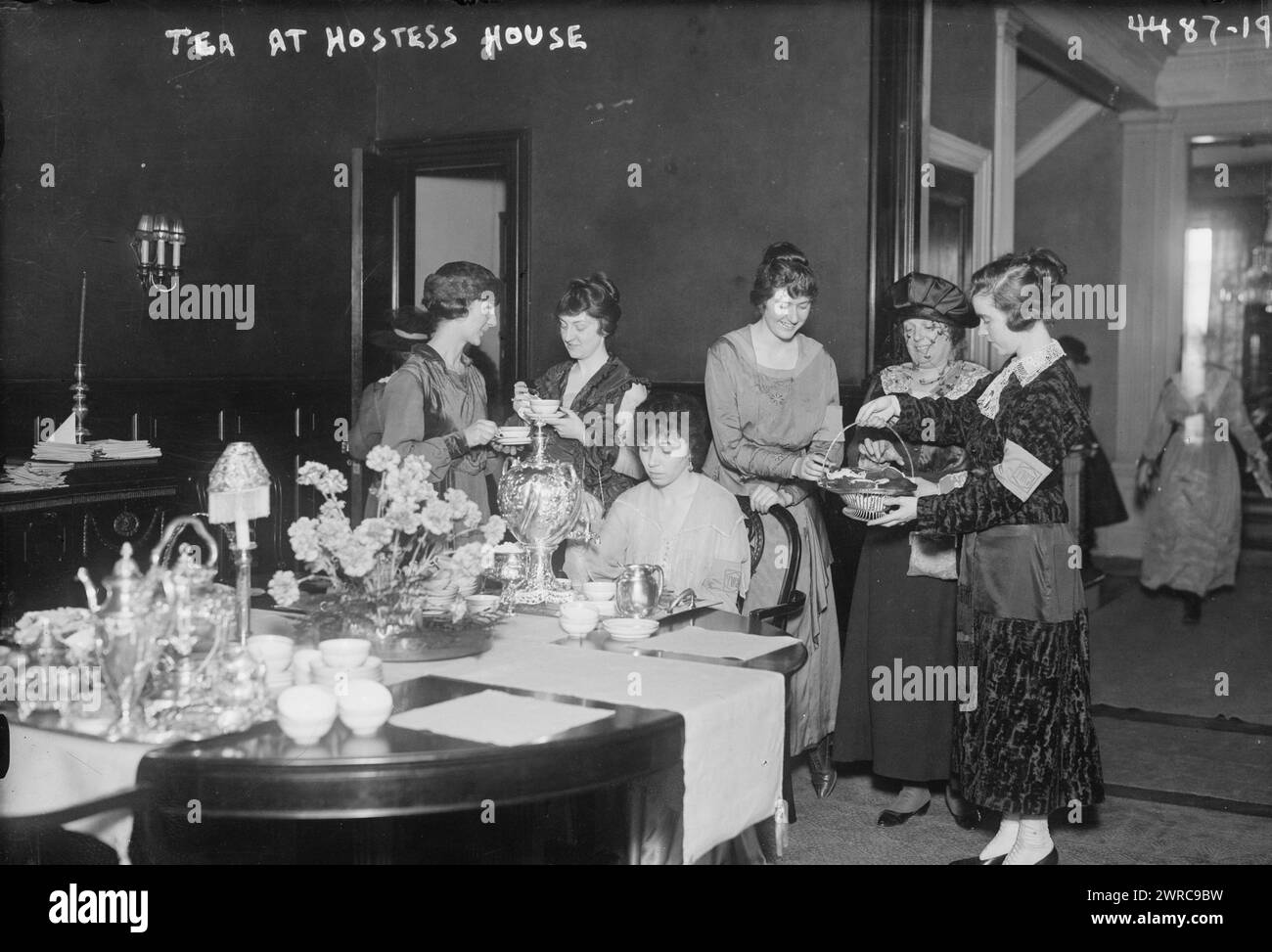 Tè alla Hostess House, la fotografia mostra le donne che bevono il tè in una "casa di hostess" probabilmente in un campo militare durante la prima guerra mondiale Le case delle hostess sono state create dal War Work Council della YWCA., tra ca. 1915 e 1918, Guerra Mondiale, 1914-1918, Glass negative, 1 negative: Glass Foto Stock