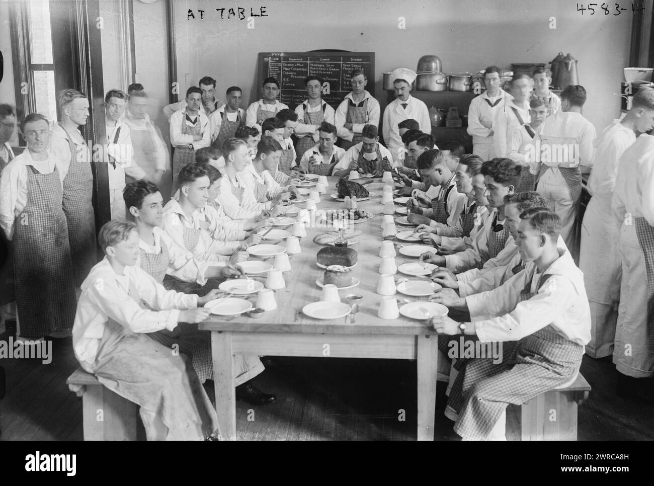 A tavola, la fotografia mostra gli studenti seduti ad un tavolo della New York Cooking School, 126 East 59th Street. La scuola addestrava i soldati a cucinare per la Marina durante la prima guerra mondiale, tra ca. 1915 e 1918, Guerra Mondiale, 1914-1918, Glass negative, 1 negative: Glass Foto Stock