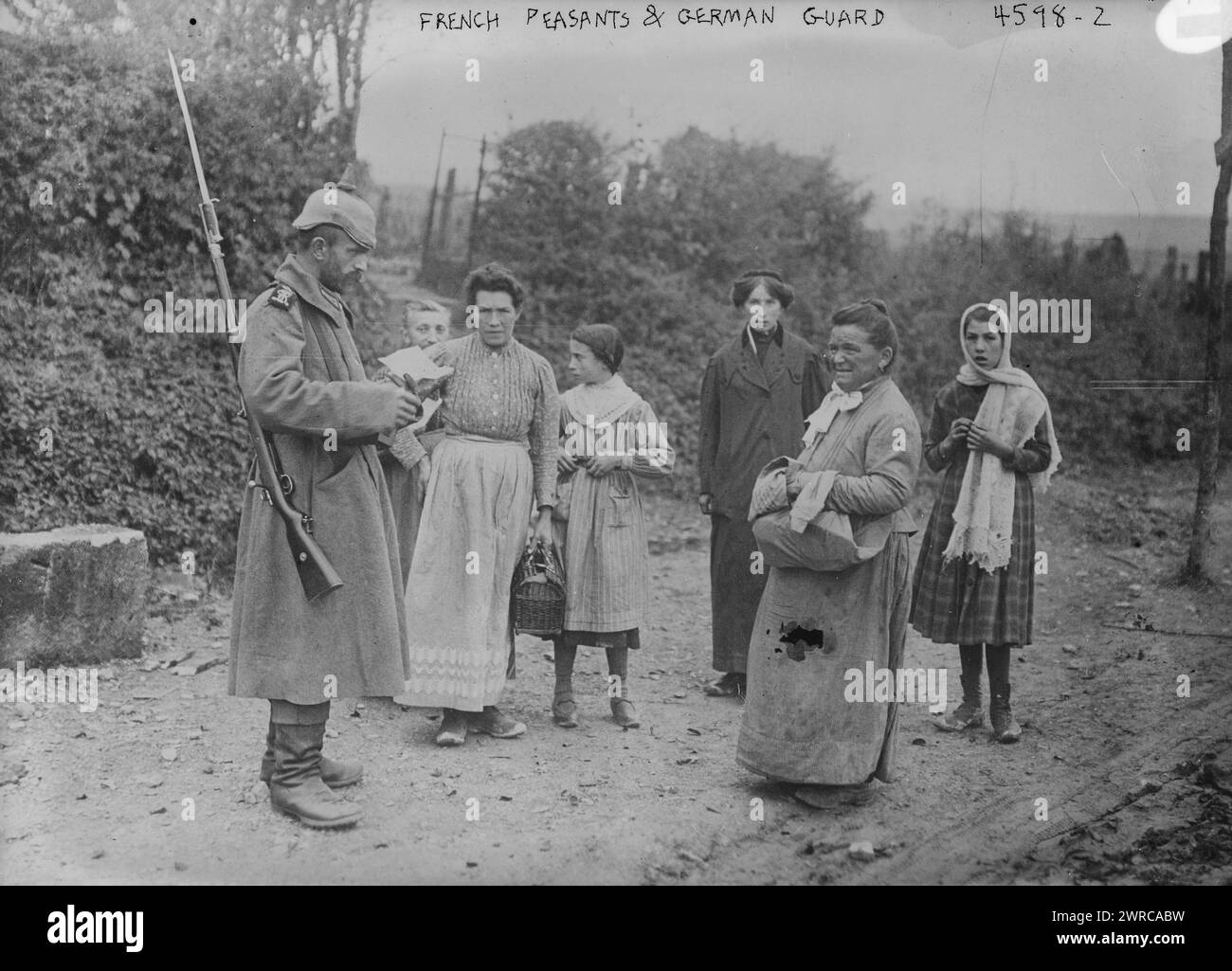 Contadini francesi e guardie tedesche, la fotografia mostra donne e ragazze francesi in piedi con un soldato tedesco in una strada durante la prima guerra mondiale, tra ca. 1915 e 1918, Guerra Mondiale, 1914-1918, Glass negative, 1 negative: Glass Foto Stock