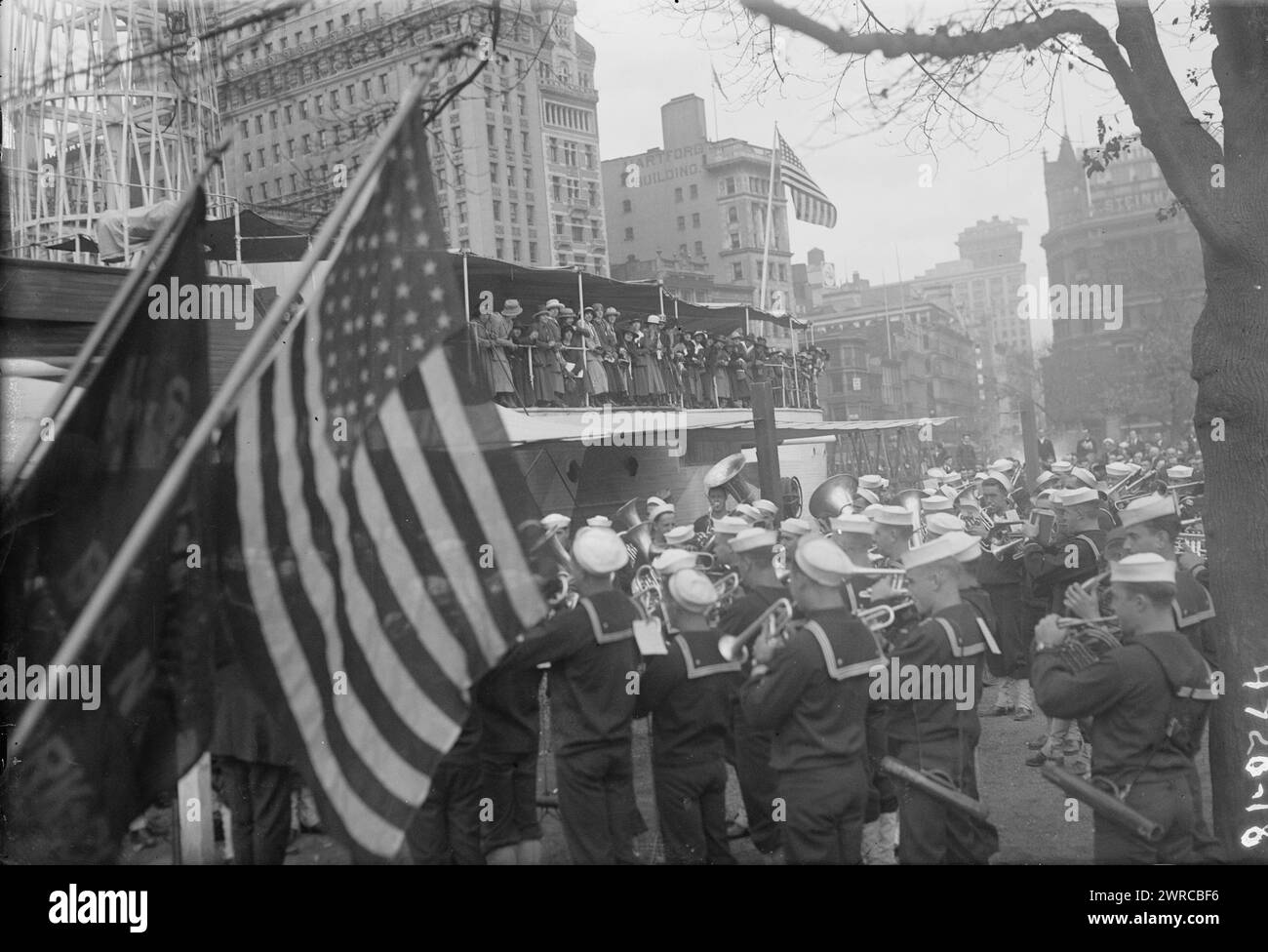 Parade, la fotografia mostra la banda militare che suona di fronte alla recluta USS, un mockup di legno di una nave da guerra costruita a Union Square, New York City dalla Marina per reclutare marinai e vendere obbligazioni Liberty durante la prima guerra mondiale Le donne francesi stanno sul ponte della nave, tra ca. 1915 e ca. 1920, Glass negative, 1 negativo: Glass Foto Stock