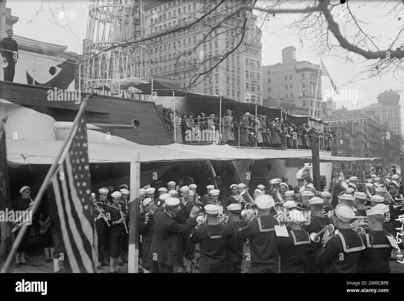 Donne francesi su RECLUTA, la fotografia mostra una banda militare che suona accanto alla recluta USS, un mockup di legno di una nave da battaglia costruita a Union Square, New York City dalla Marina per reclutare marinai e vendere obbligazioni Liberty durante la prima guerra mondiale Donne francesi in piedi sul ponte., 1917 o 1918, Guerra Mondiale, 1914-1918, negativi di vetro, 1 negativo: vetro Foto Stock