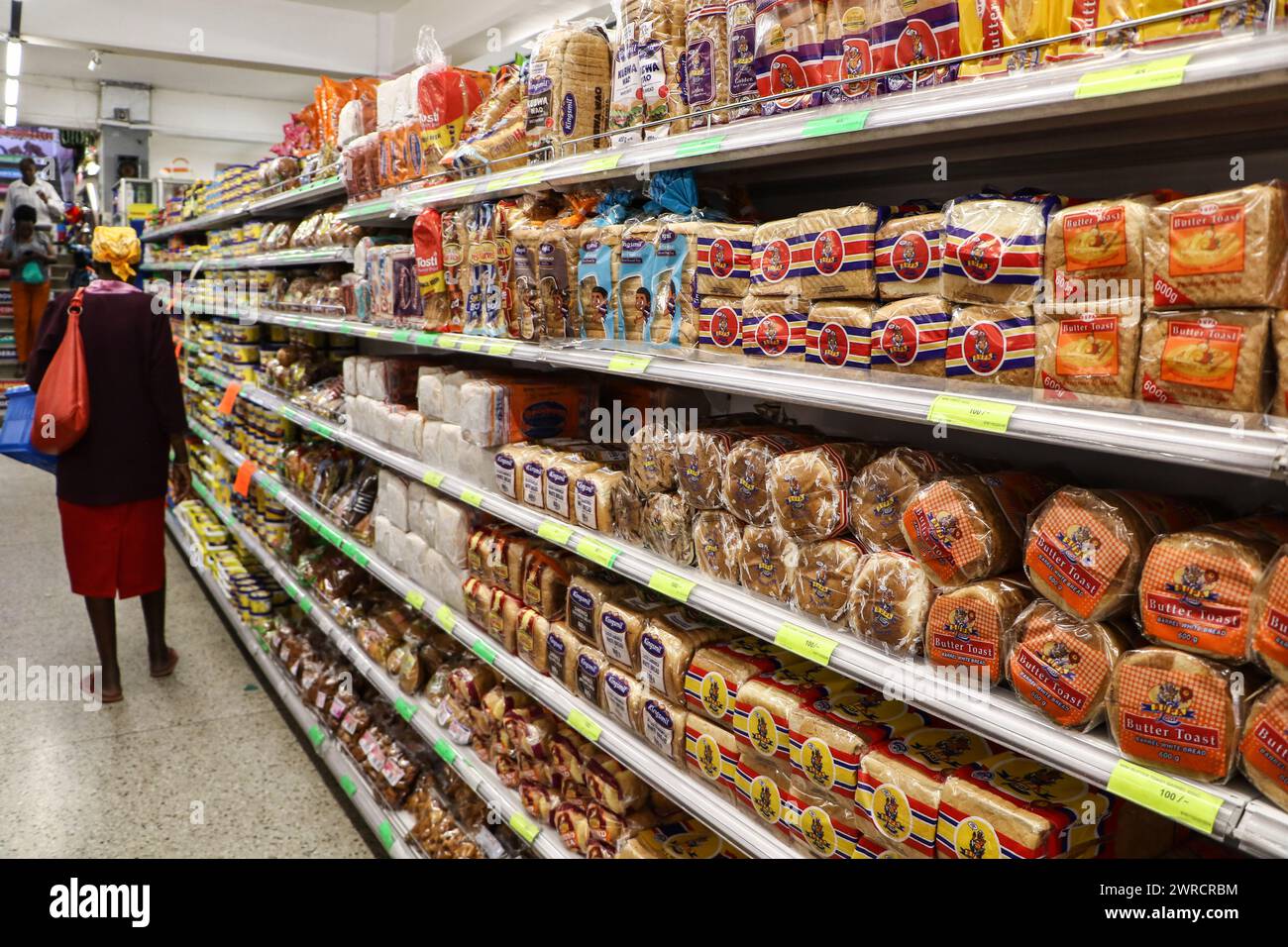 Nakuru, Kenya. 11 marzo 2024. Un cliente si trova di fronte agli scaffali con pani di pane in un supermercato di Nakuru City. Secondo i dati della Banca centrale del Kenya (CBK), il tasso di inflazione del Kenya è sceso al 6,3% a febbraio, in calo dal 6,9% di gennaio. Si tratta di un valore minimo di 23 mesi, attribuito a una diminuzione del costo degli alimenti essenziali e del carburante. Credito: SOPA Images Limited/Alamy Live News Foto Stock